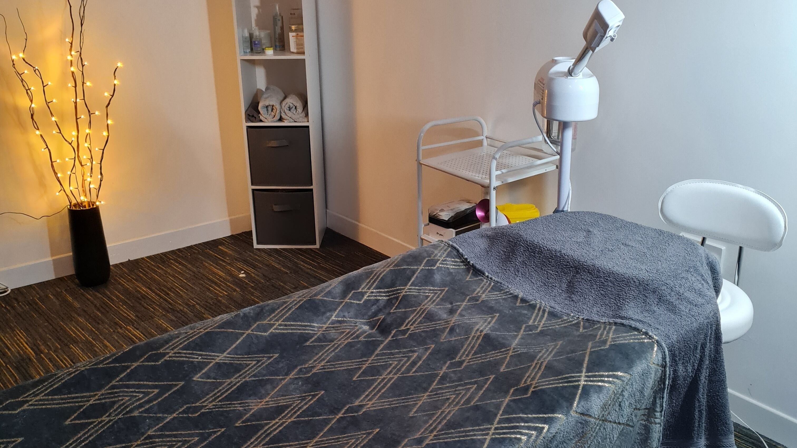 Relaxing spa room at Filipa's Aesthetics and Beauty, Norwich, England, GB with soft lighting and treatment bed.