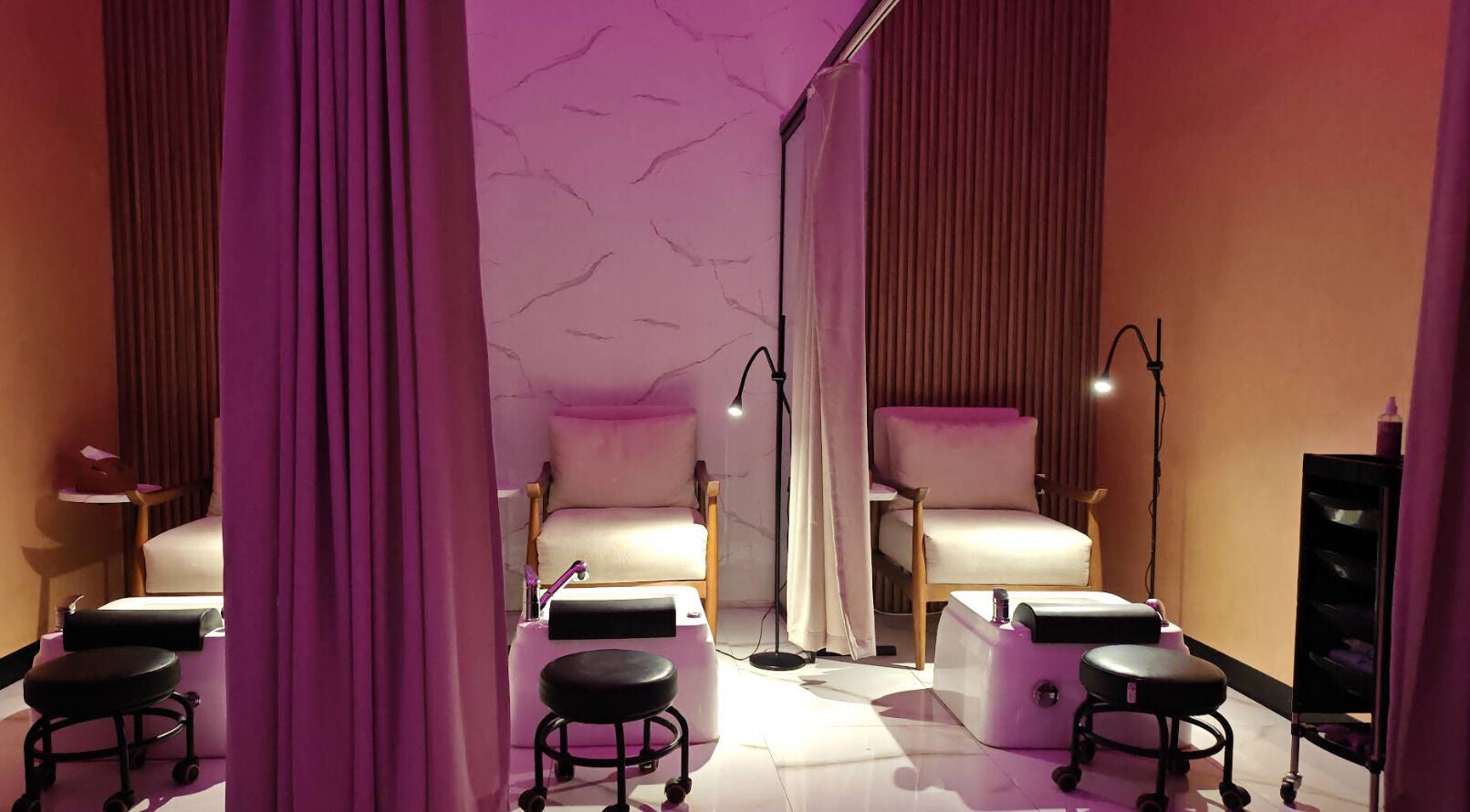 Relaxing pedicure chairs at Lucky Spa, Riyadh, Riyadh Province, SA, illuminated by soft purple lighting.