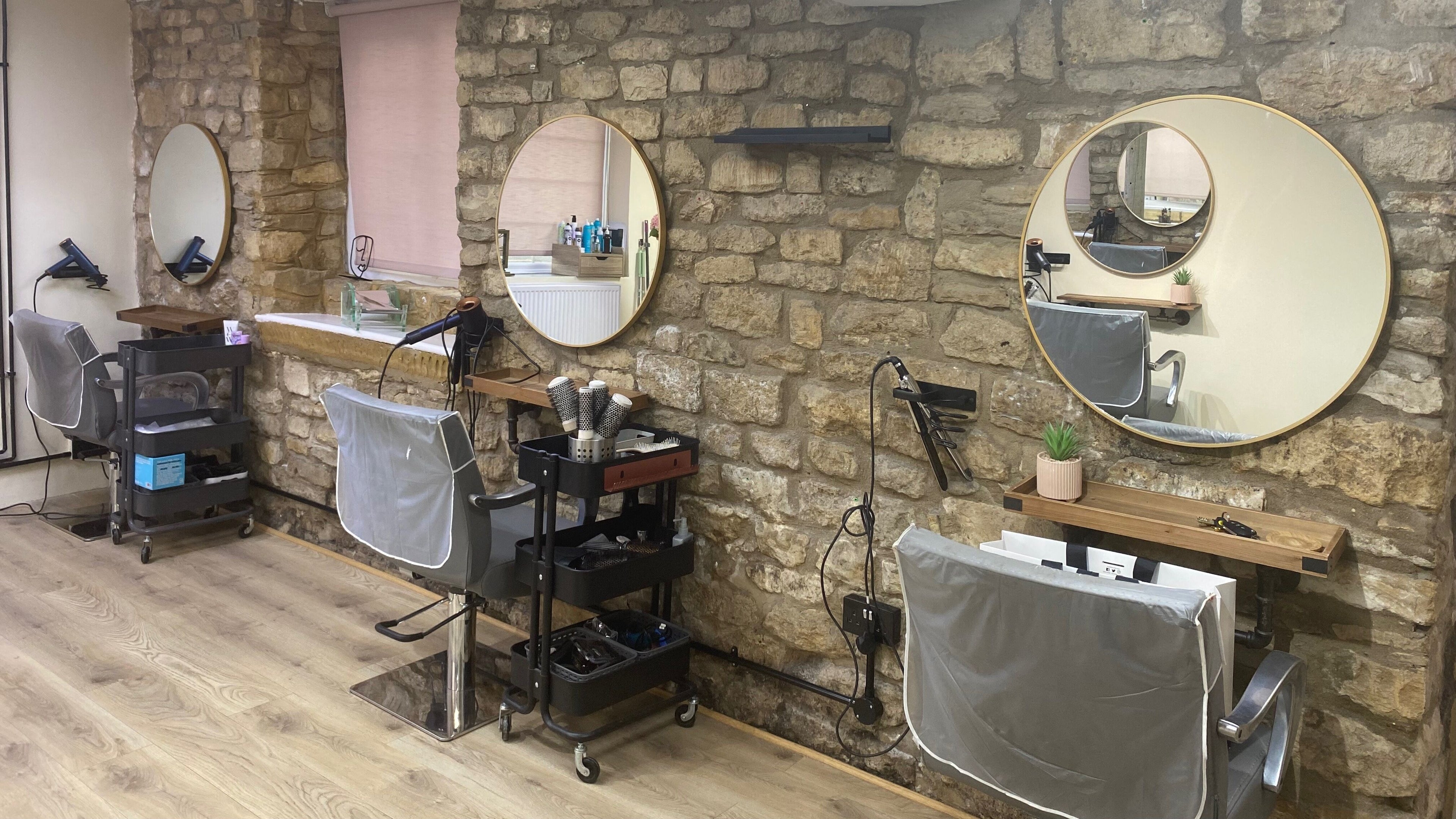Chic hairdressing stations with round mirrors at 5th Avenue, Weldon, England, GB. Cozy and stylish interior.