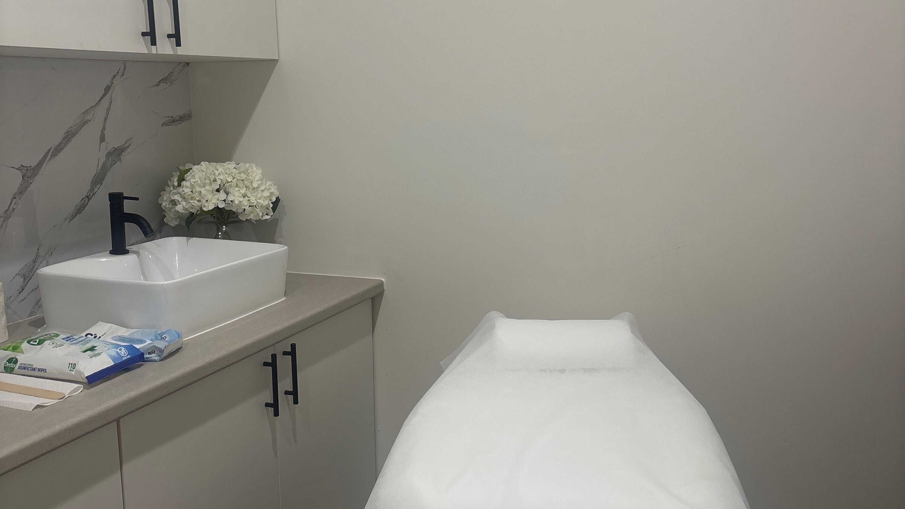 Therapy room at Naked Beauty Melbourne, featuring a massage table and elegant decor in Melbourne, Victoria, AU.