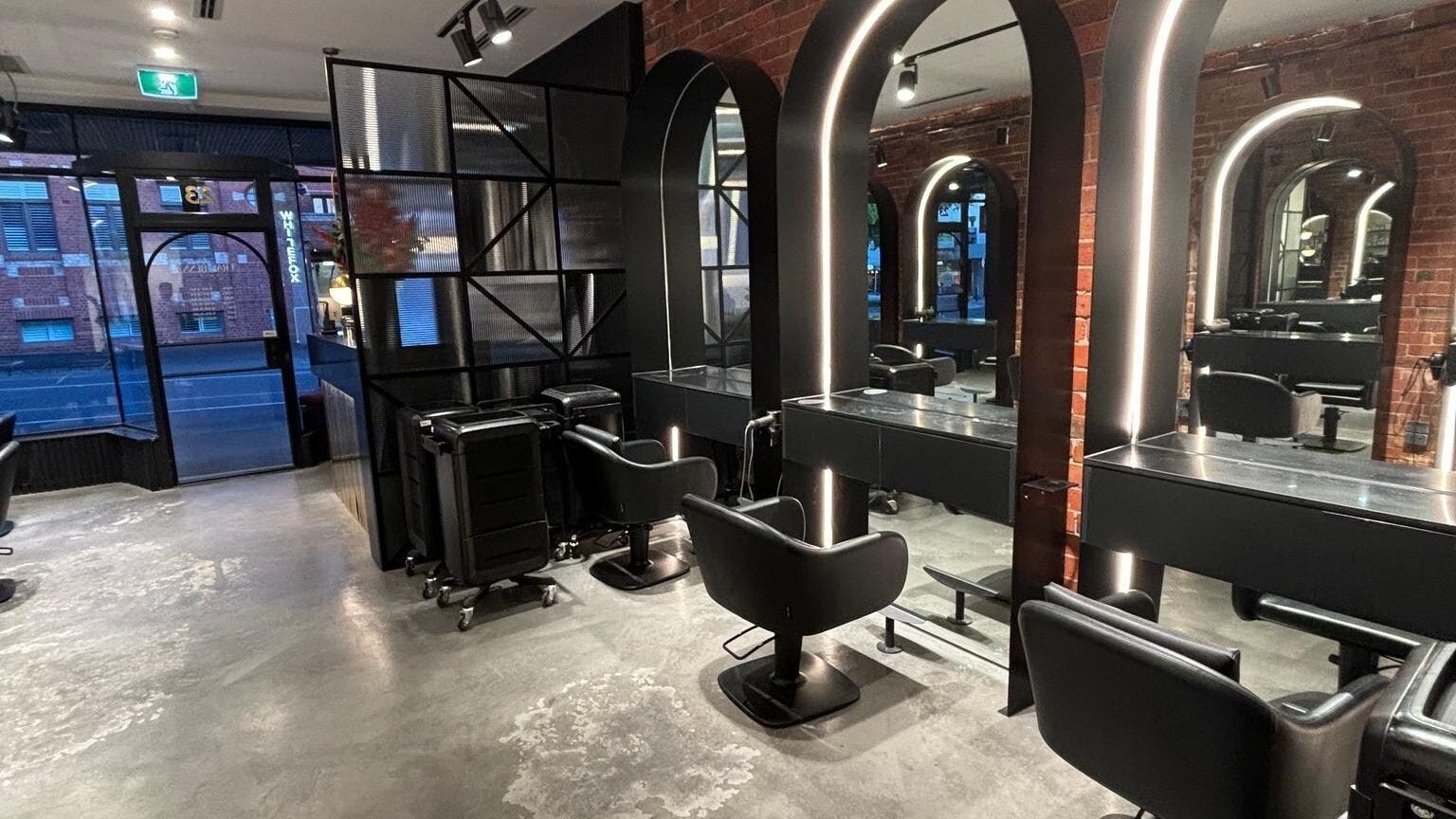 Chic salon interior at Eran Benn, Melbourne, Victoria, AU, featuring modern styling stations and illuminated mirrors.