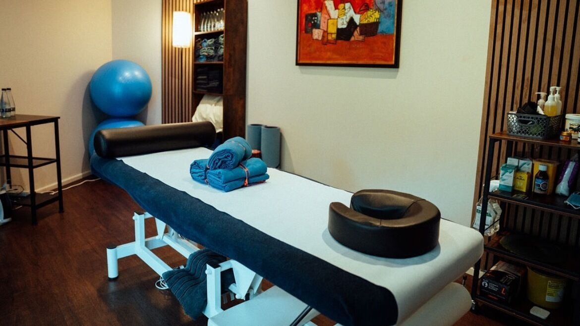 Calming massage room at YK Wellness in London, England, GB, featuring a massage table and tranquil decor.