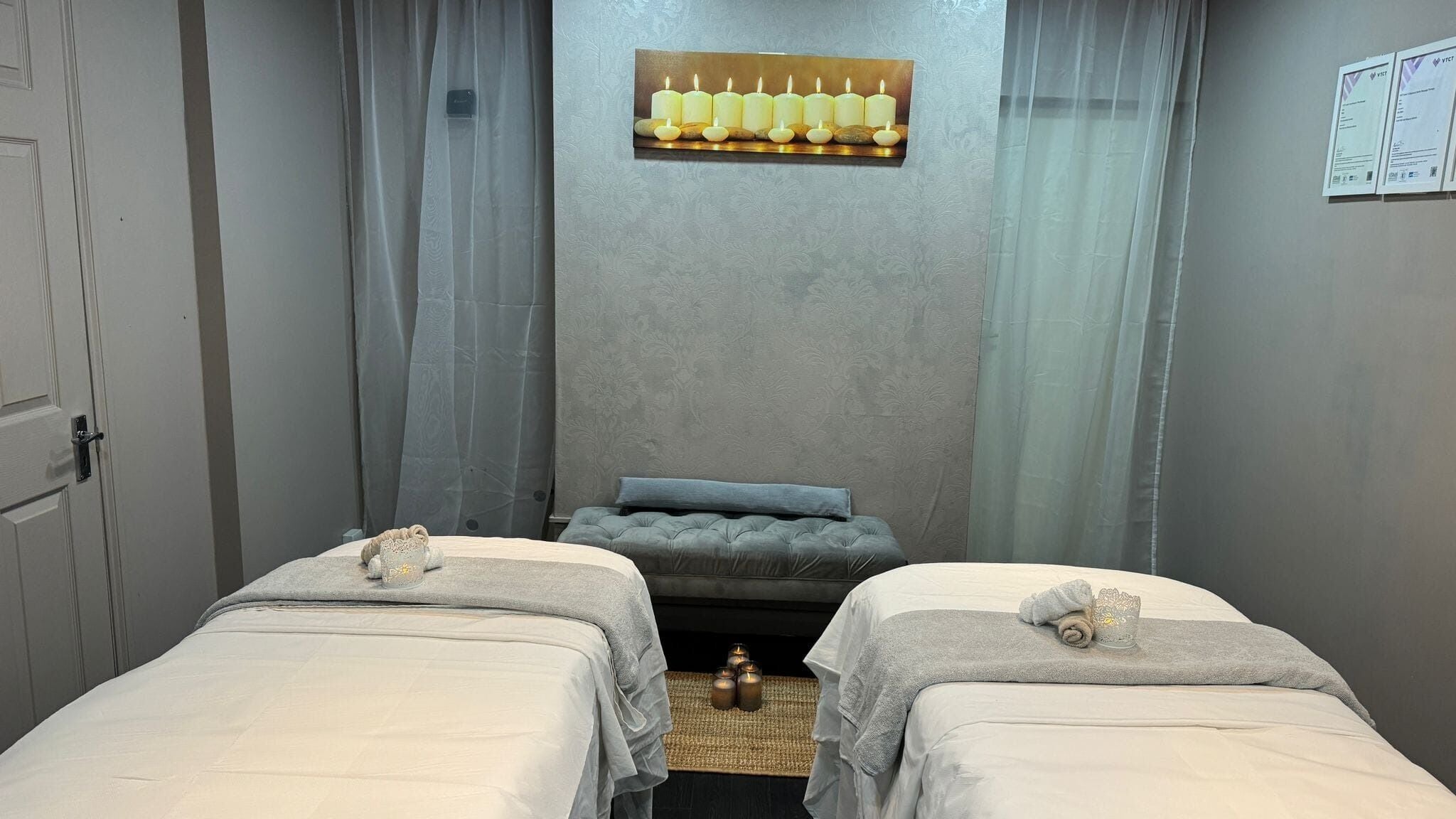 Relaxing massage room with twin beds at Montra Therapy, Grays, England, GB, featuring soothing candle decor.