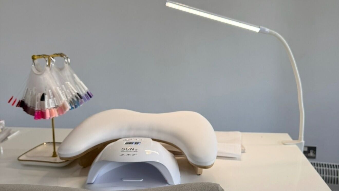 Manicure station at Lemon Tree Nails & Beauty, Cardiff, Wales, GB with nail polish display and UV lamp.