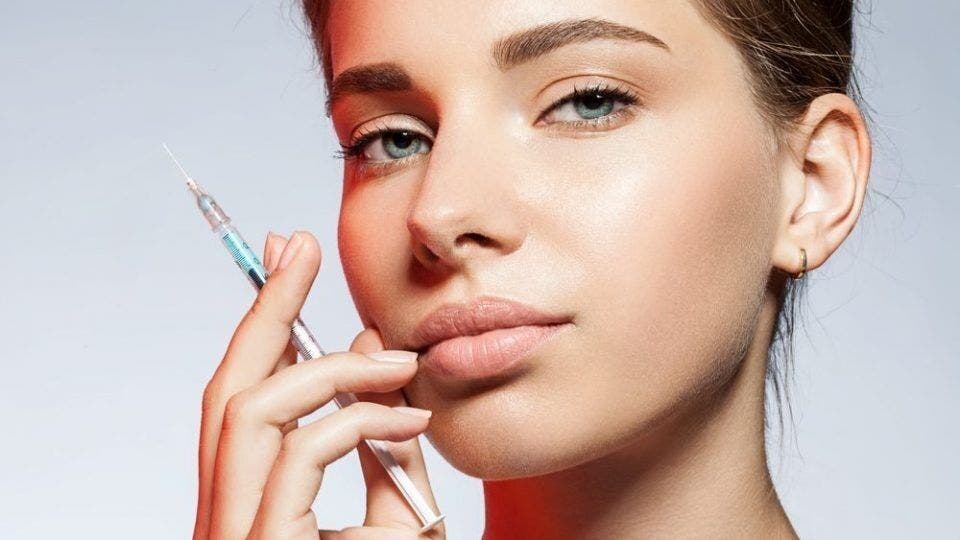 Woman with syringe at LV Beauty Aesthetics, London, England, GB, highlighting beauty and wellness service.