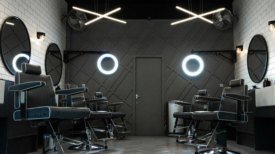 Modern barbershop interior at Kropper in London, England, GB with sleek chairs and stylish lighting.
