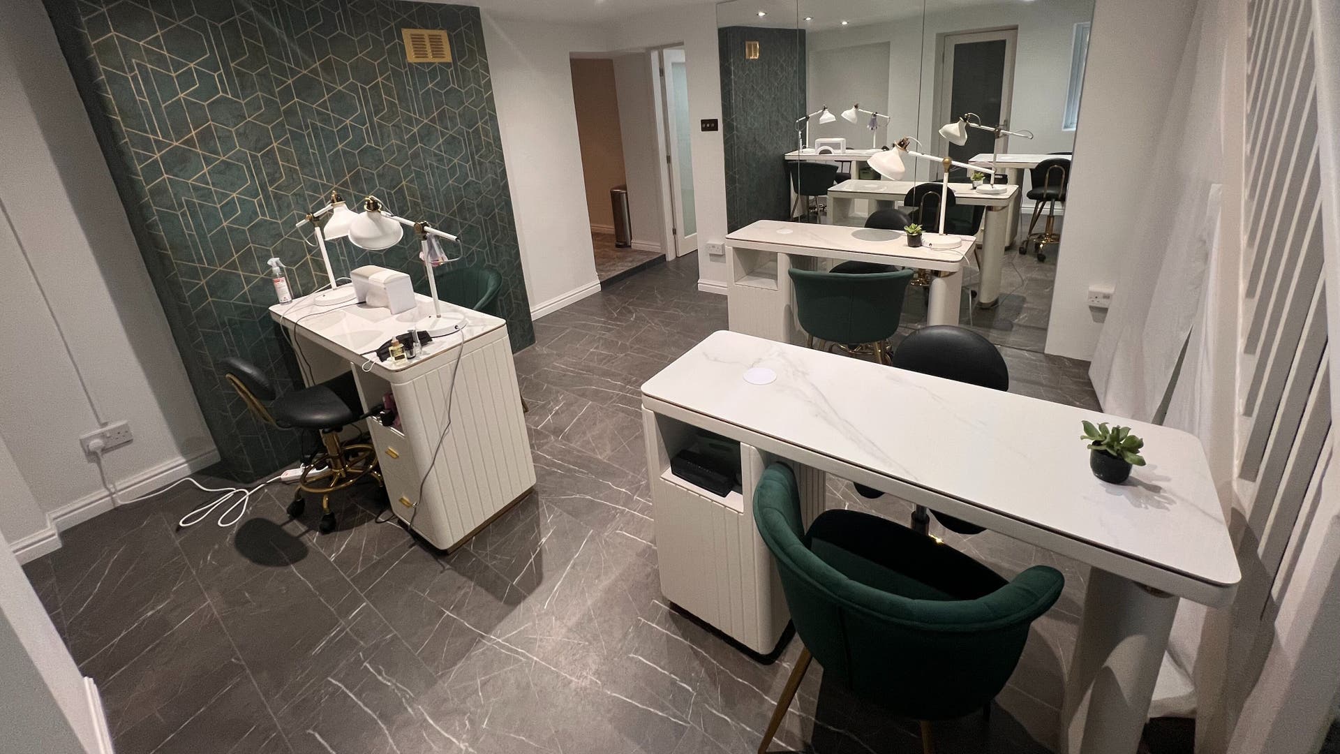 Stylish nail station at Beauty House 73, London, England, GB with green chairs and elegant decor.