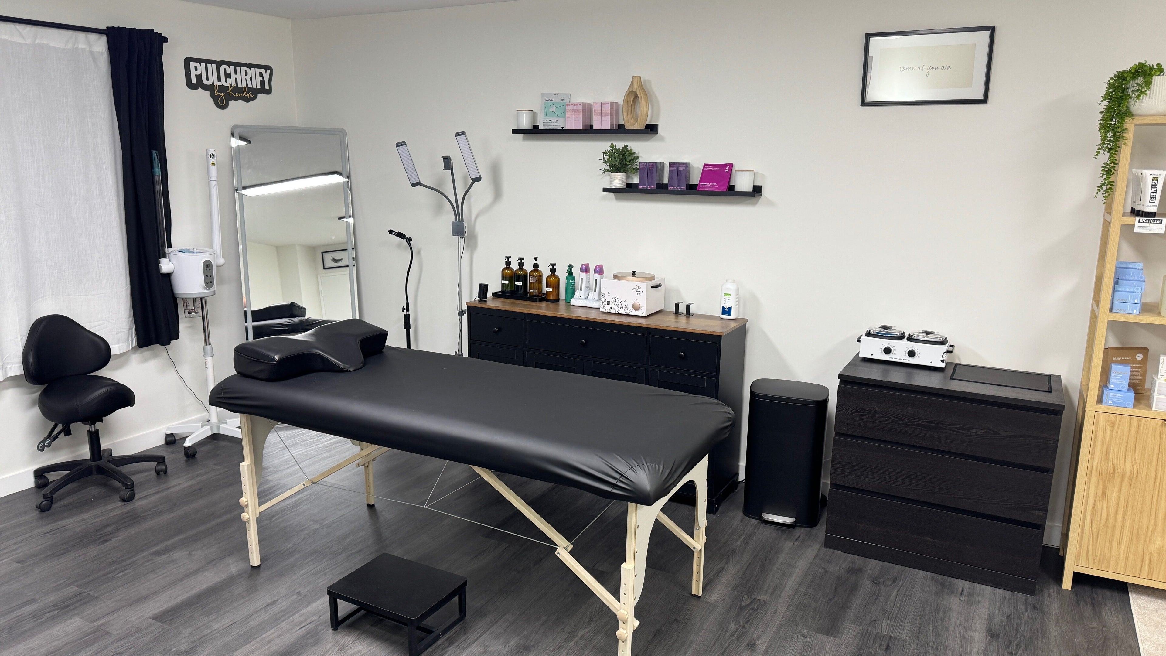 Elegant treatment room at Pulchrify by Kendra in Downey, California, US, showcasing modern black massage table.