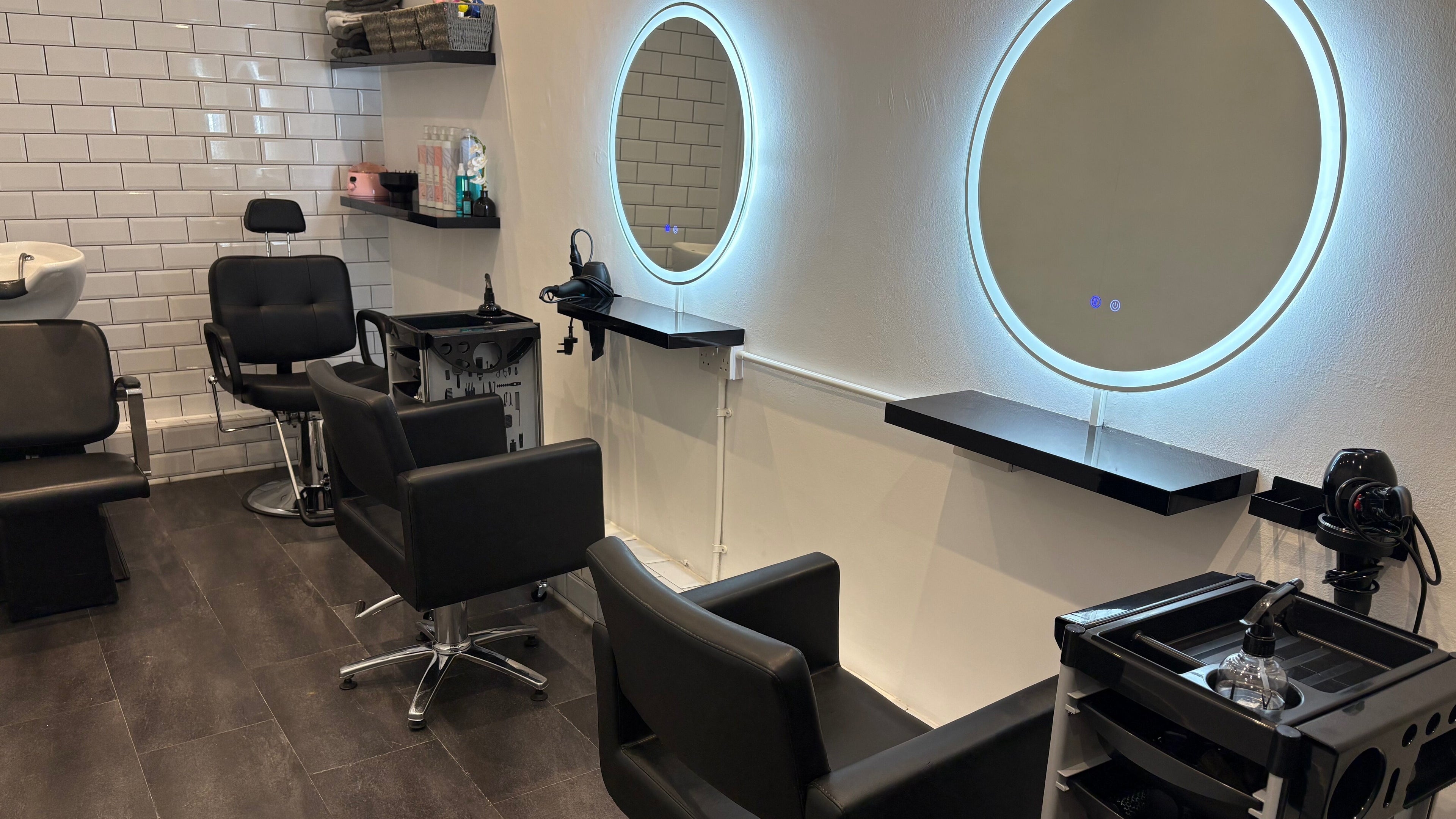 Modern salon setup at The Little Hair Room, Ayr, Scotland, GB with illuminated mirrors and styling chairs.