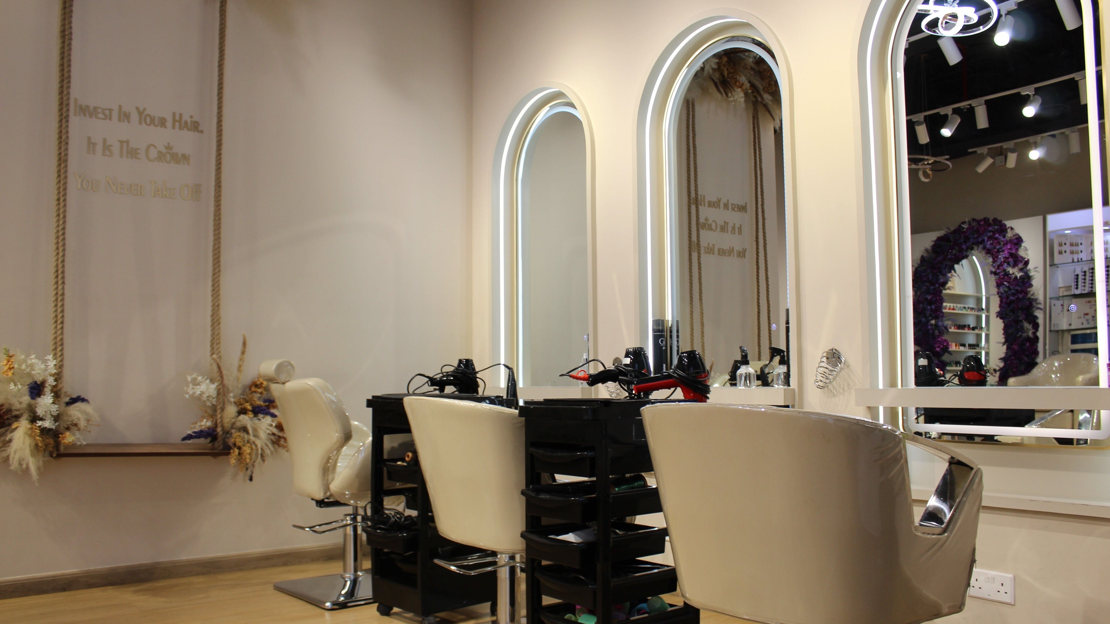 Modern styling stations at Femaled Beauty Salon, Dubai, AE, featuring elegant mirrors and plush chairs.