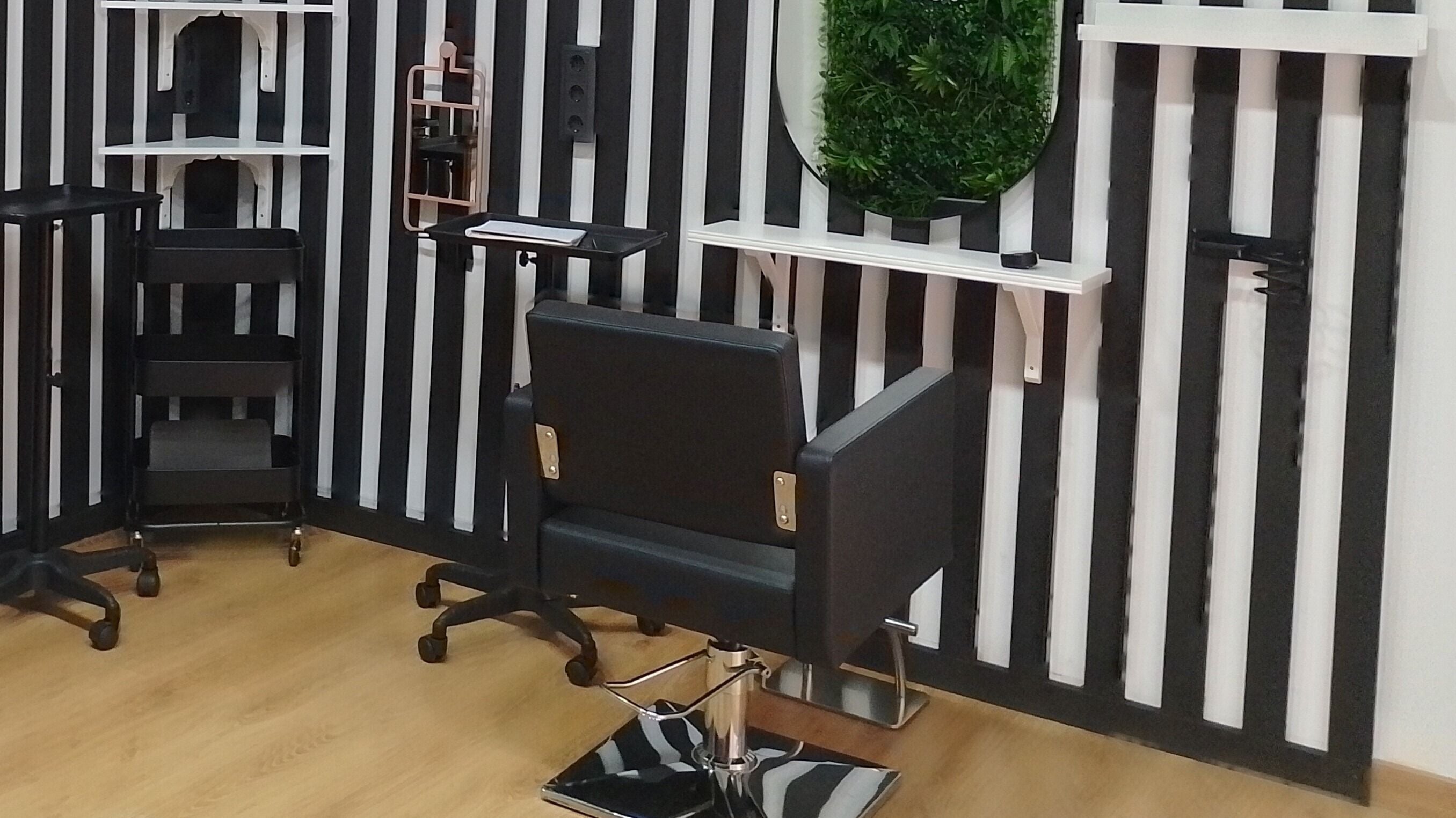 Silla moderna en FOLK Hair Salon, Barcelona, Catalunya, ES, con pared de rayas en blanco y negro.