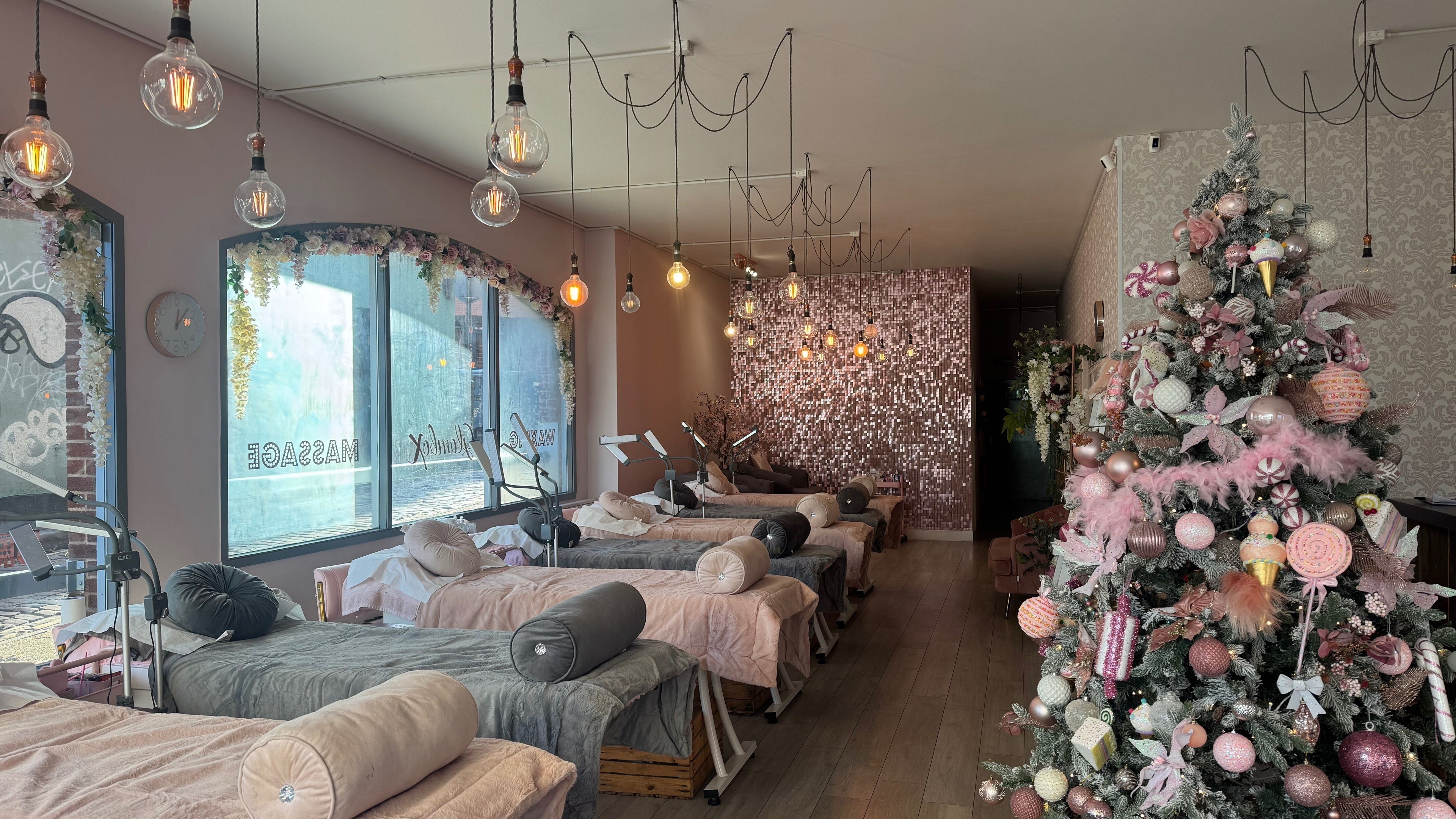 Decorative interior of Glambox in Norwich, England, featuring massage beds and festive decor.