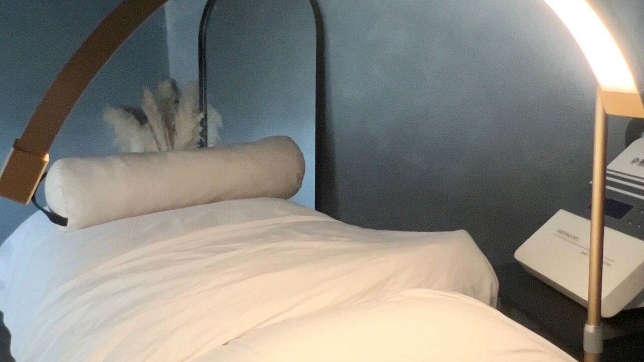 Luxurious treatment bed at Noney Skin, Glasgow, Scotland, GB, set in a calming spa environment.