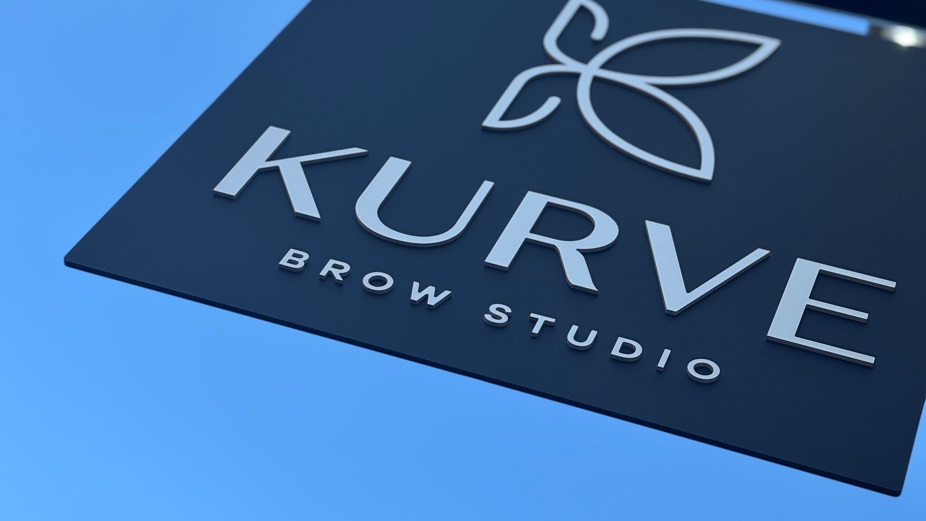 Keroline Carvalho's stylish Kurve Brow Studio sign in Sevenoaks, England, GB under clear sky.