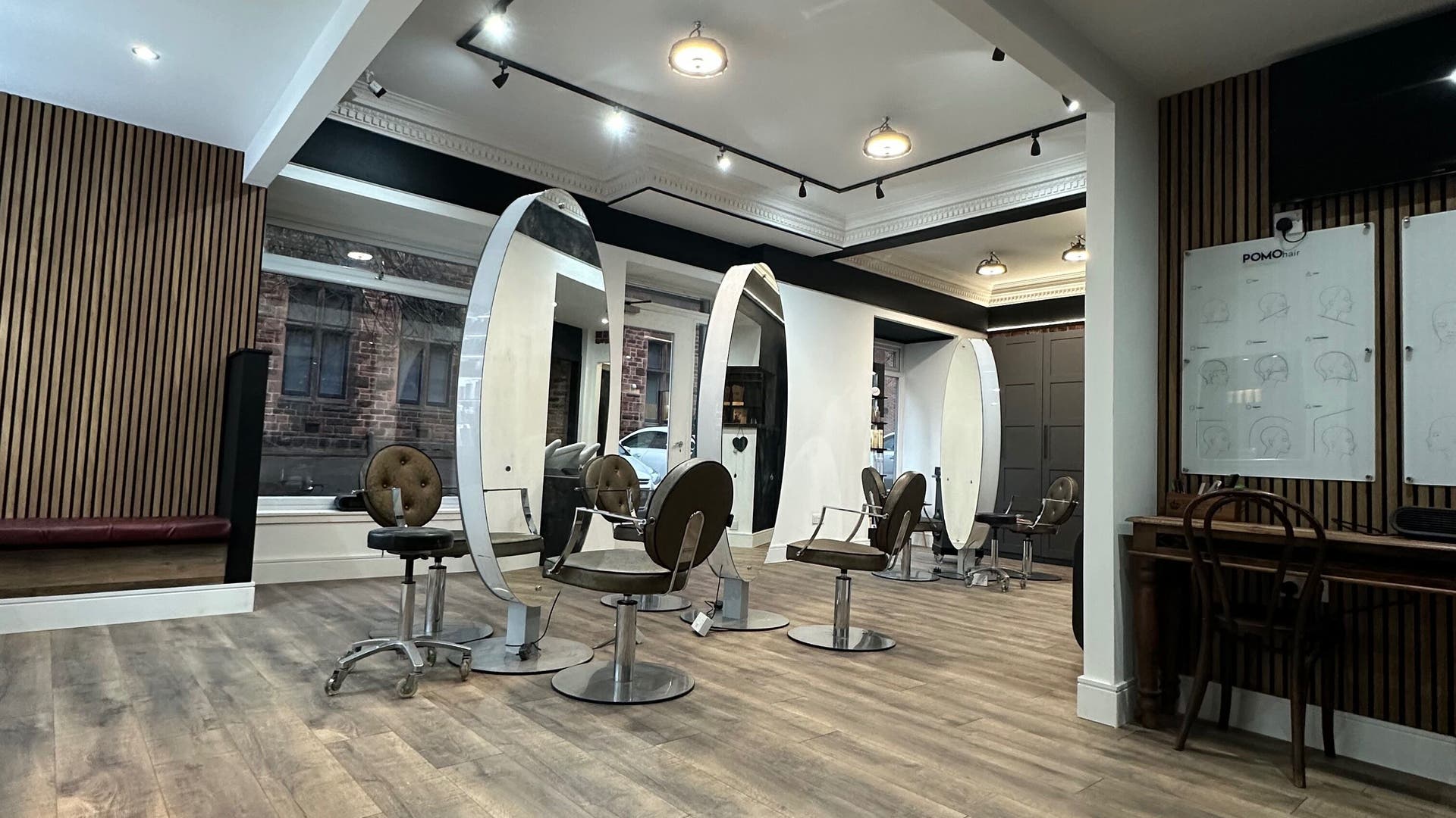 Elegant salon chairs and mirrors at POMOhair, Glasgow, Scotland, GB, showcasing a modern and stylish interior.