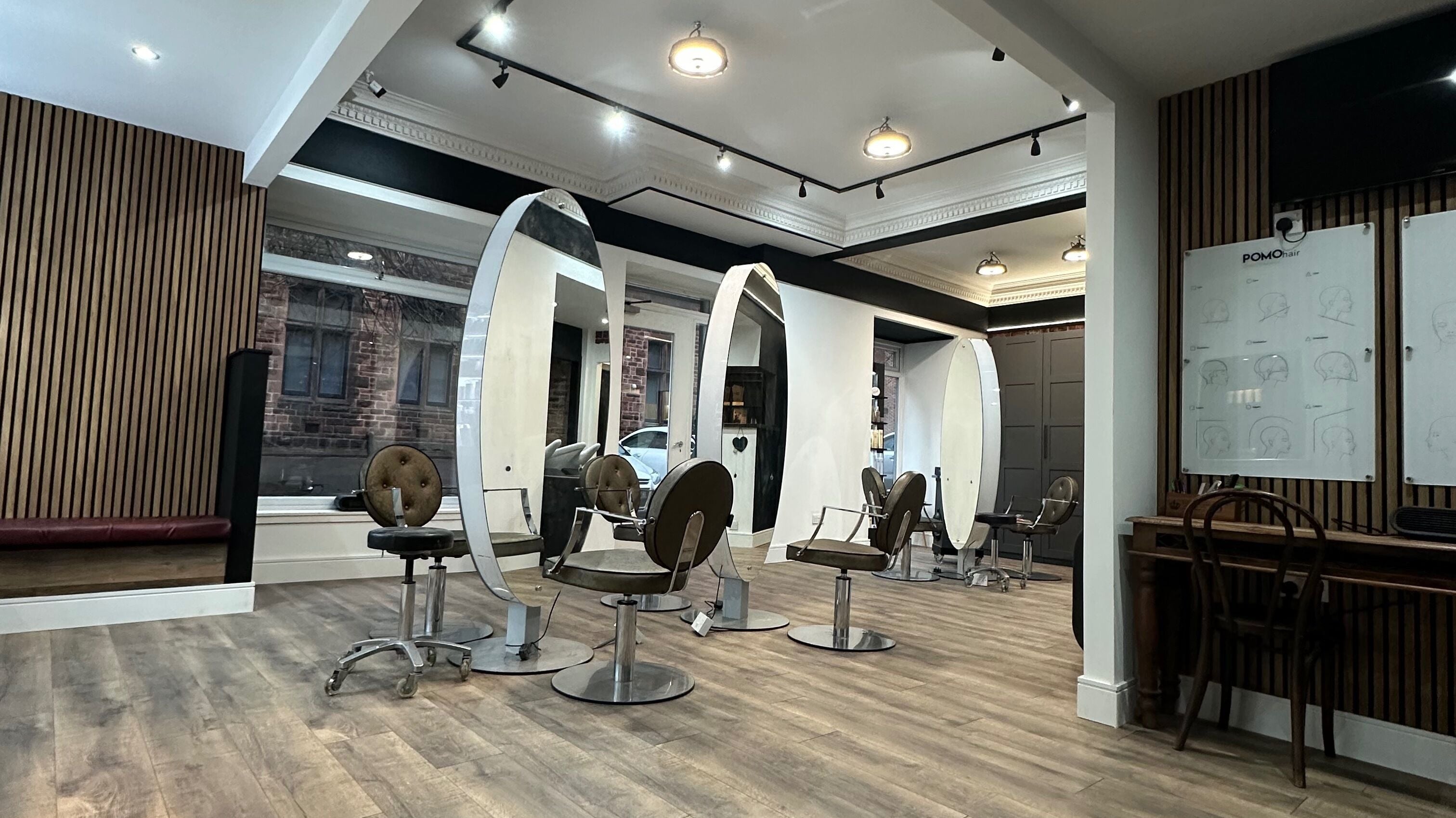 Elegant salon chairs and mirrors at POMOhair, Glasgow, Scotland, GB, showcasing a modern and stylish interior.