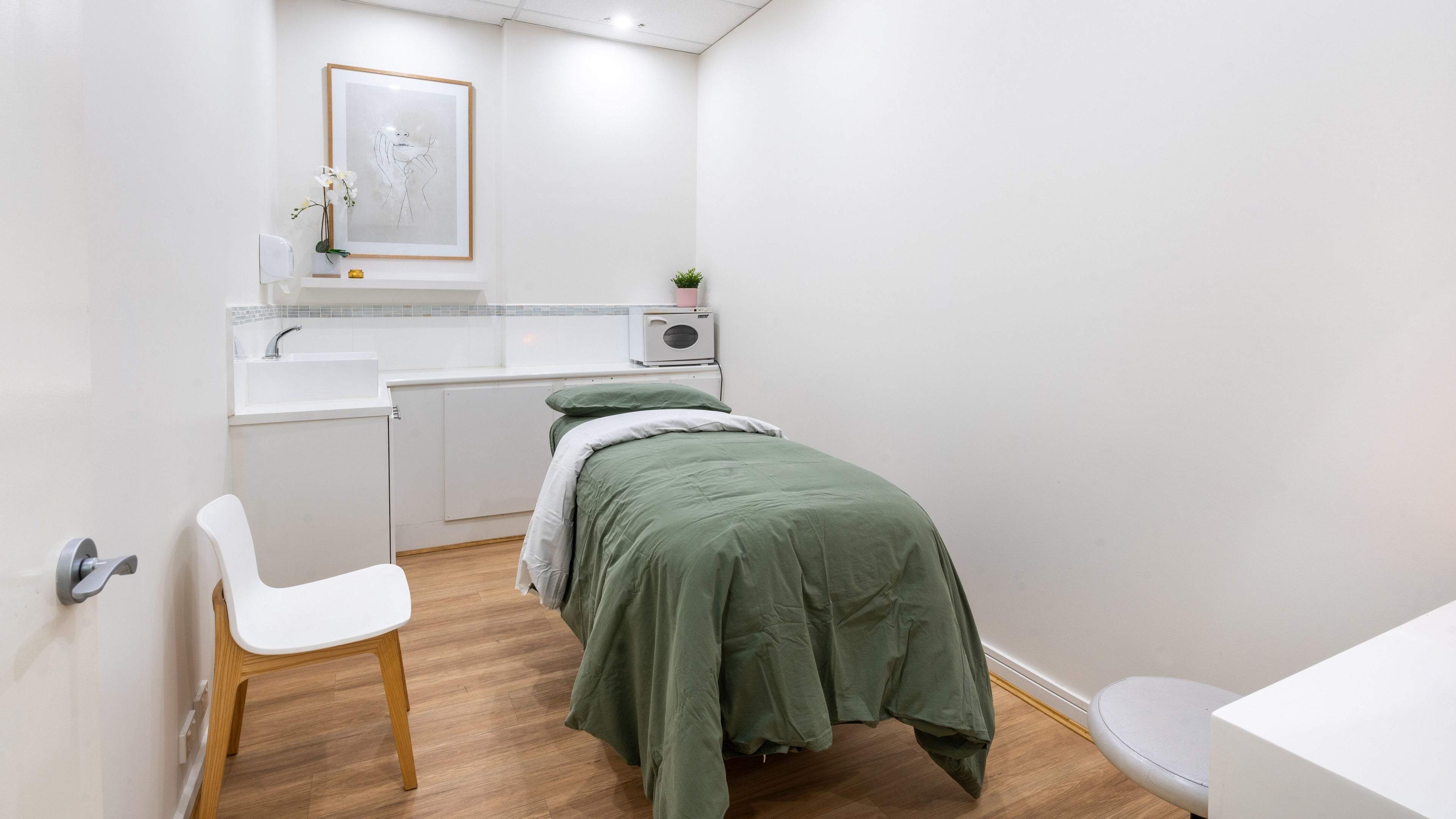 Kay + Co Cosmetic Rejuvenation's tranquil treatment room in Highett, Victoria, AU, featuring a green-clad bed.