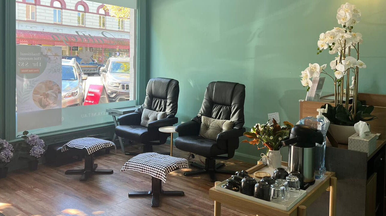 Cozy seating area at Cattleya Thai Massage & Waxing in Melbourne, Victoria, AU, with massage chairs and orchids.