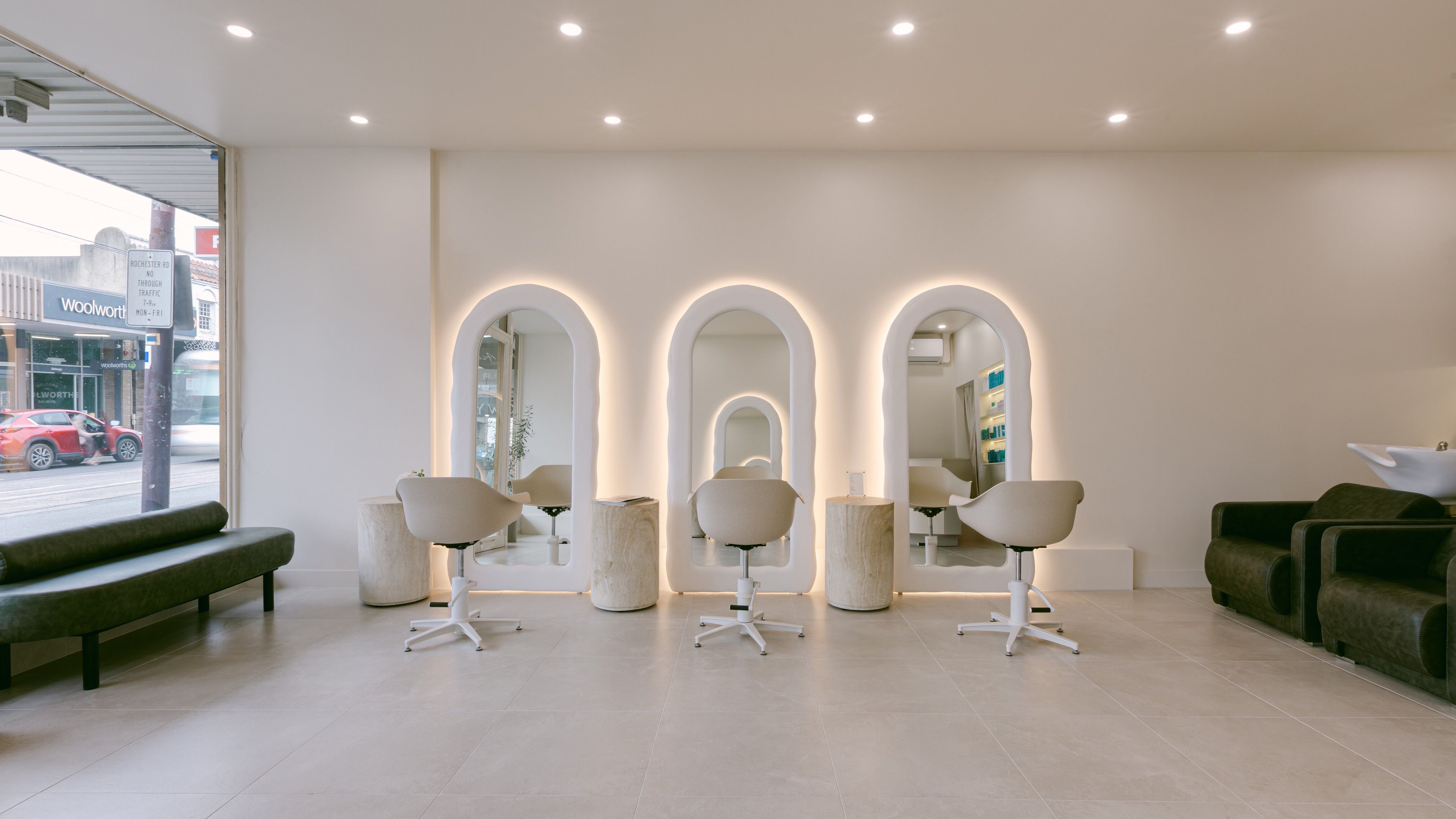 Stylish salon interior at Ador Hair Co. in Melbourne, Victoria, AU with modern chairs and illuminated mirrors.