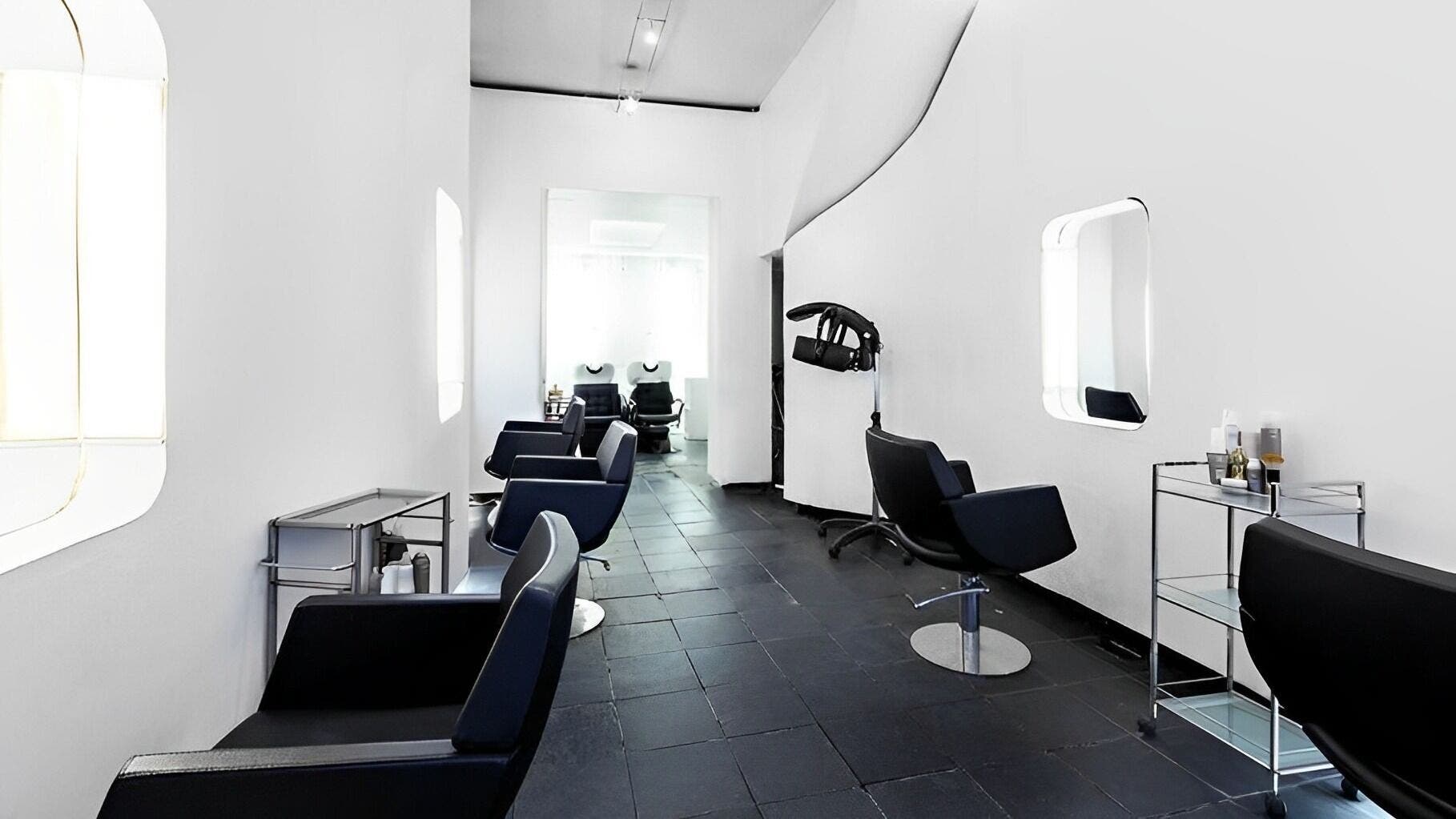 Sleek, modern salon interior at Ticro Hair, London, England, GB with chic black chairs and minimalist decor.