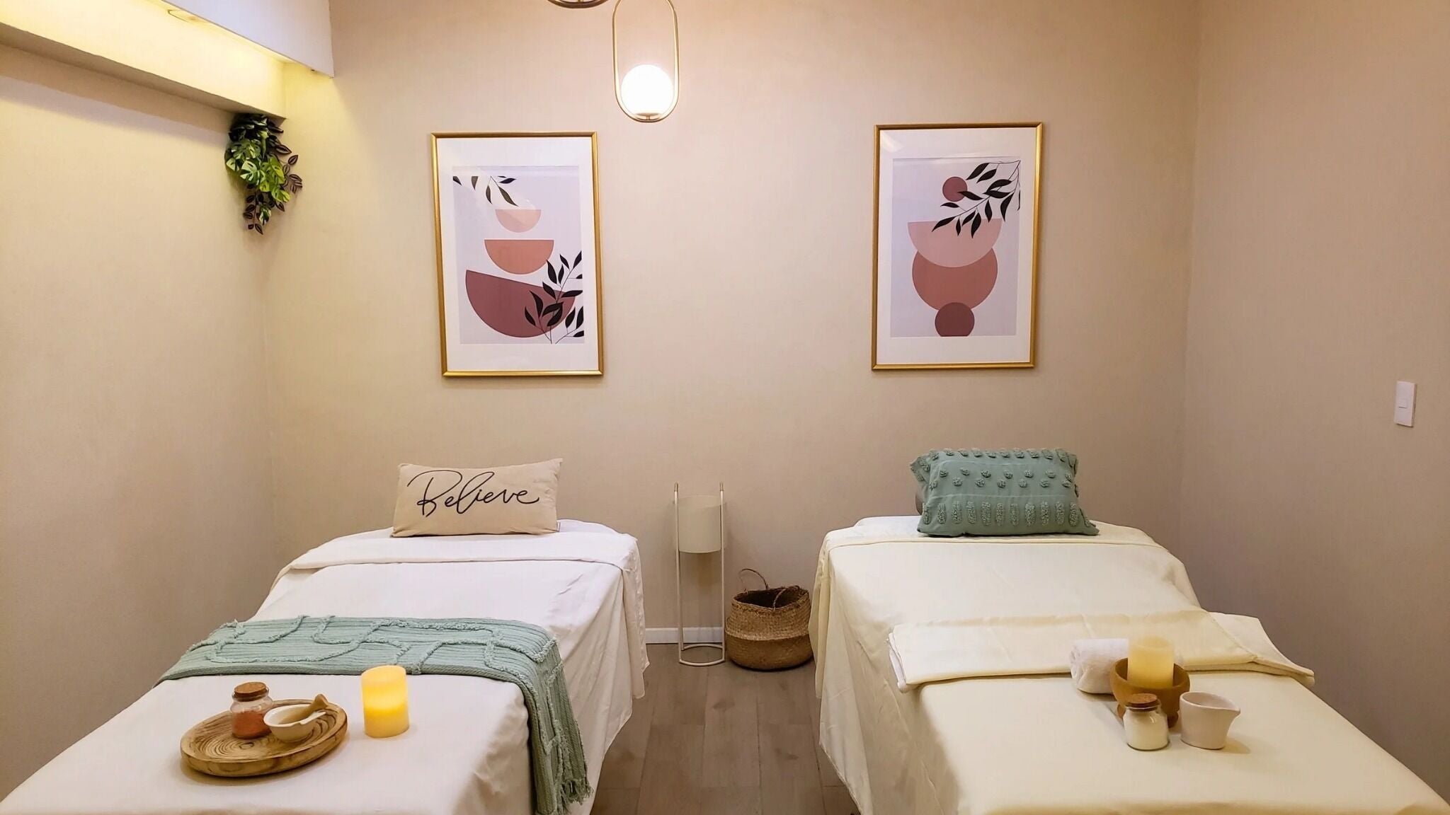 Sala de masajes con dos camas en Armonica Spa, Ciudad De México, MX, decorada con arte moderno y luz cálida.