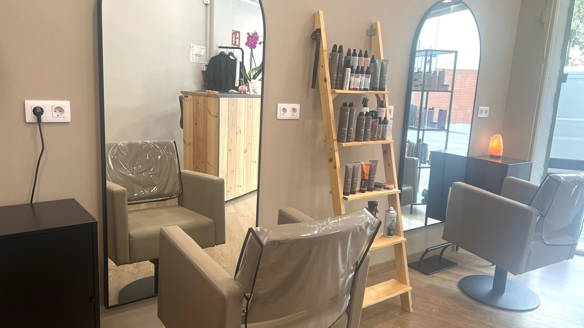 Interior moderno de SV Saray Valdivia Beauty Hair Studio en Sabadell, Catalunya, ES con espejo y estantes de productos.