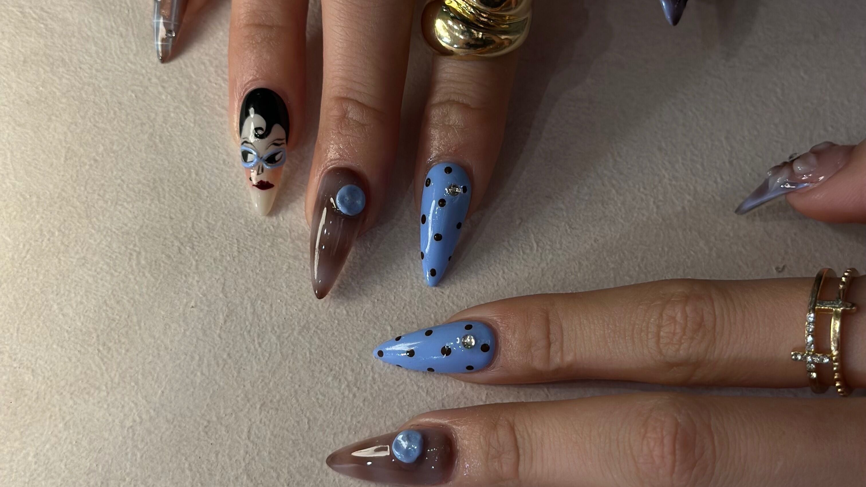Unique nail art with blue polka dots and face design at ProfessioNail Prahran, Prahran, Victoria, AU.