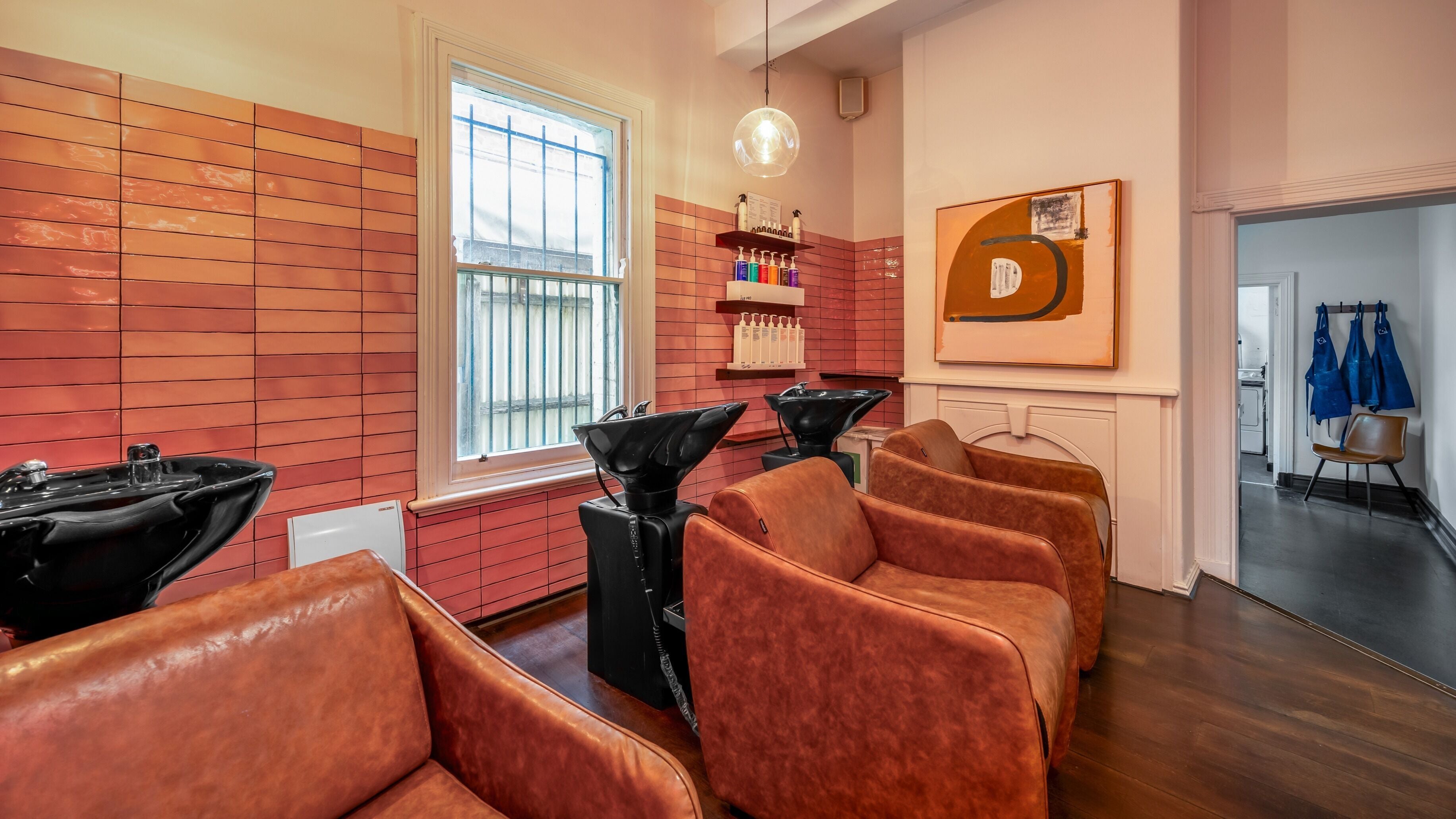 Stylish salon chairs and hair wash stations at Three Blind Mice, Melbourne, Victoria, AU. Vibrant, modern decor.