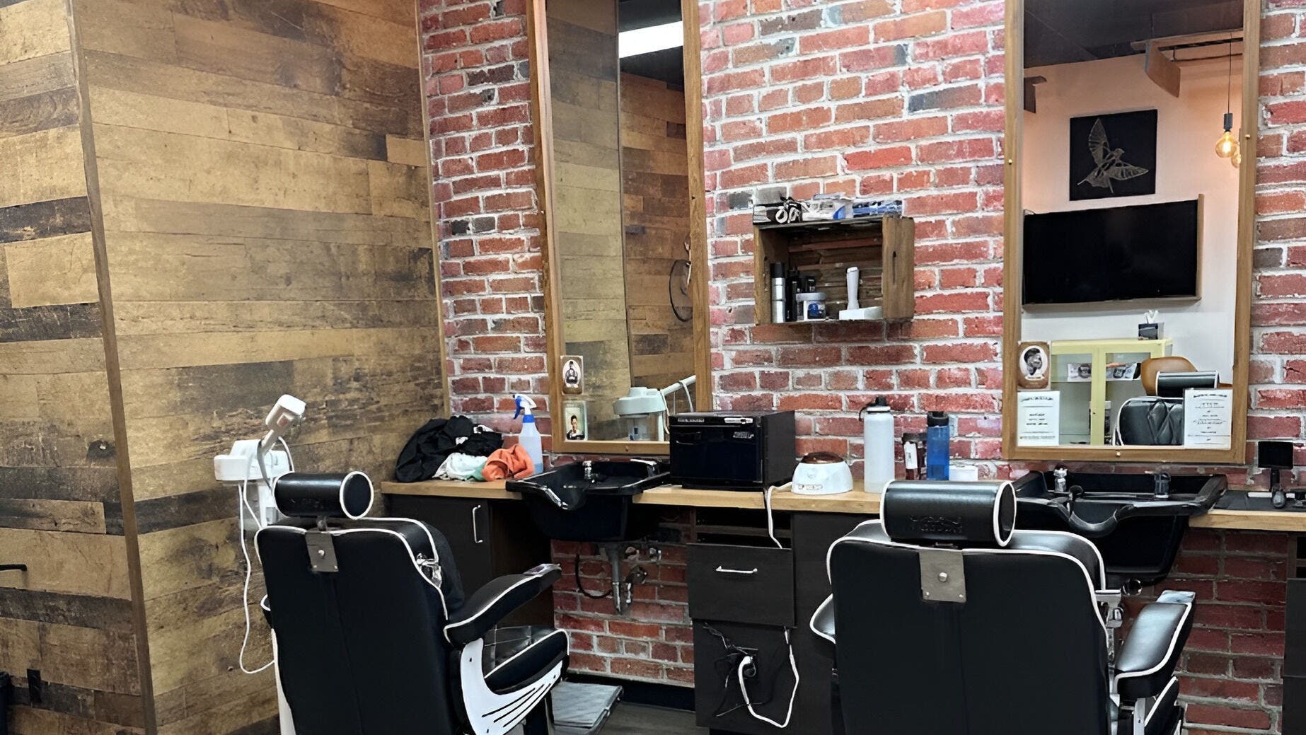 Interior of Mr. Barber Unity Square in Edmonton, Alberta, CA, featuring stylish barber chairs and rustic brick walls.