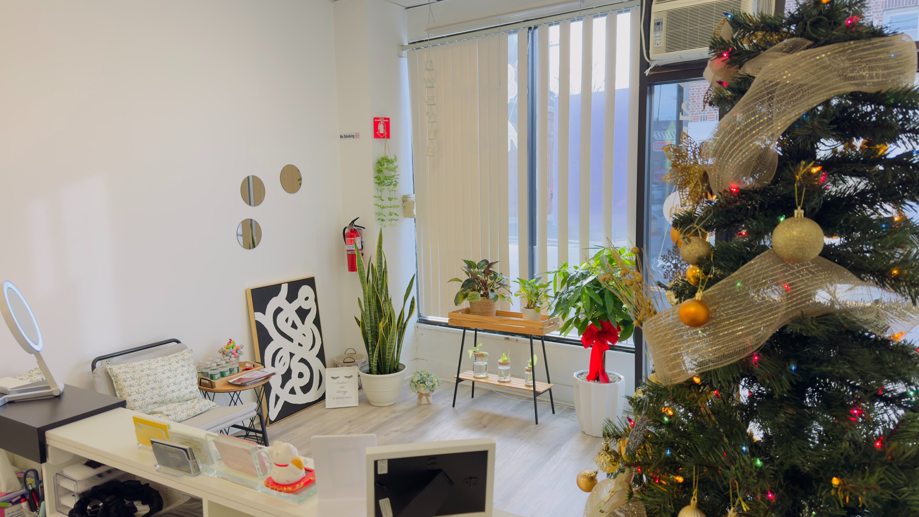Chelsea Lash Studio in Harrison, New York, features a holiday-decorated interior with plants and a Christmas tree.