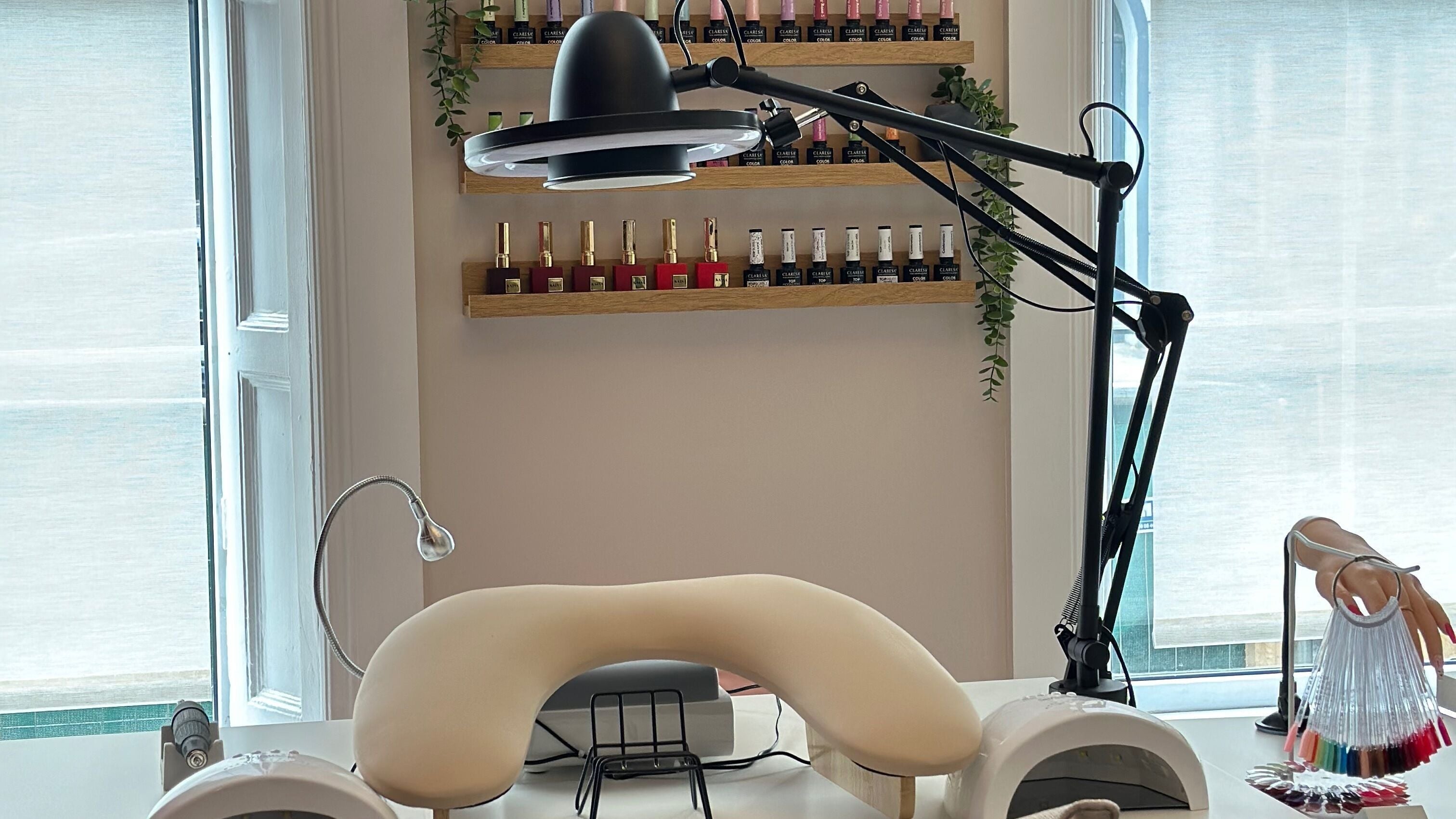 Maya Caliaro Beauty in Limerick, IE showcases a nail treatment station with cozy armrest and vibrant polish display.
