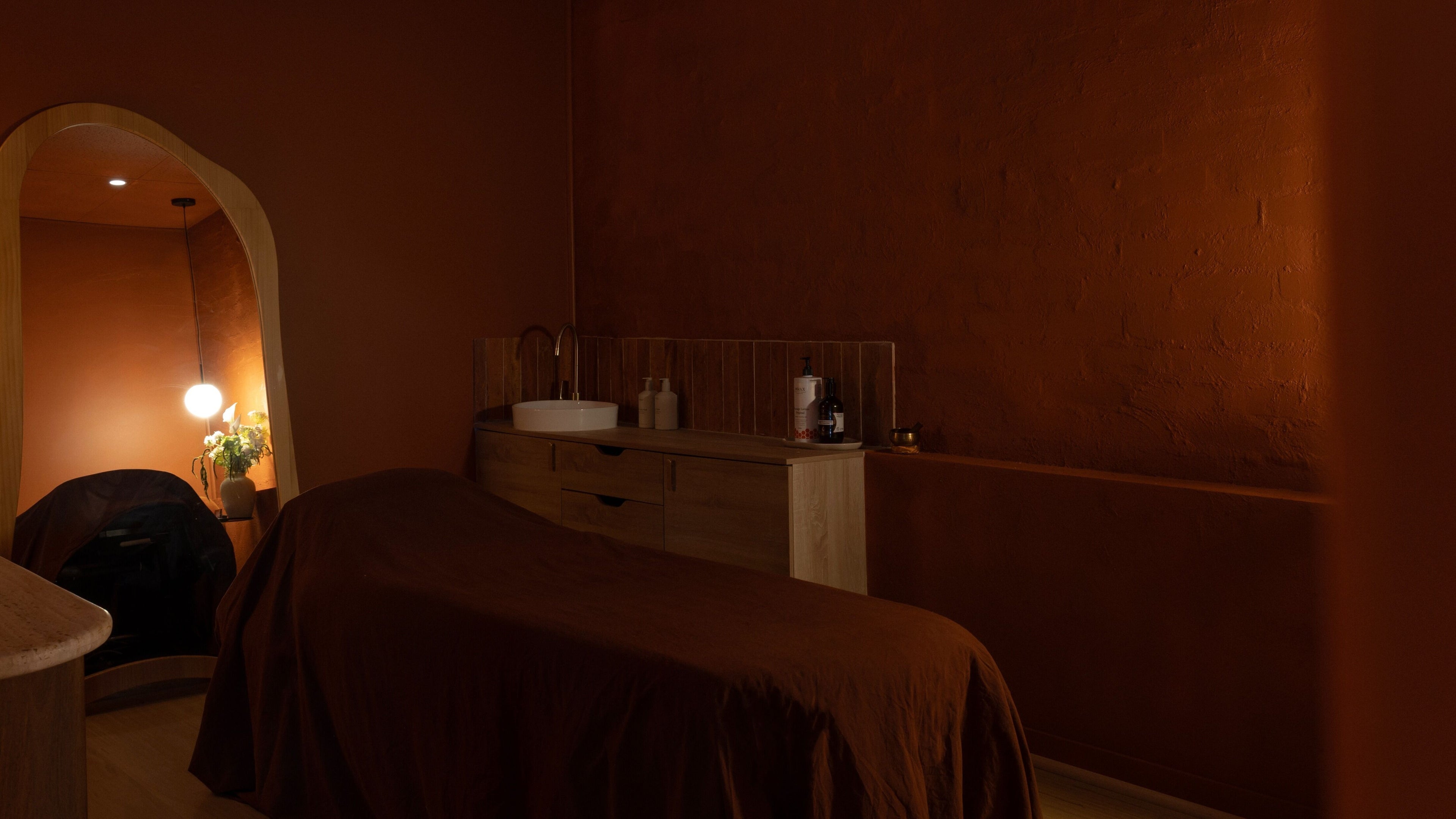 Warm, tranquil treatment room at Just Studio, Melbourne, Victoria, AU with soft lighting and cozy decor.