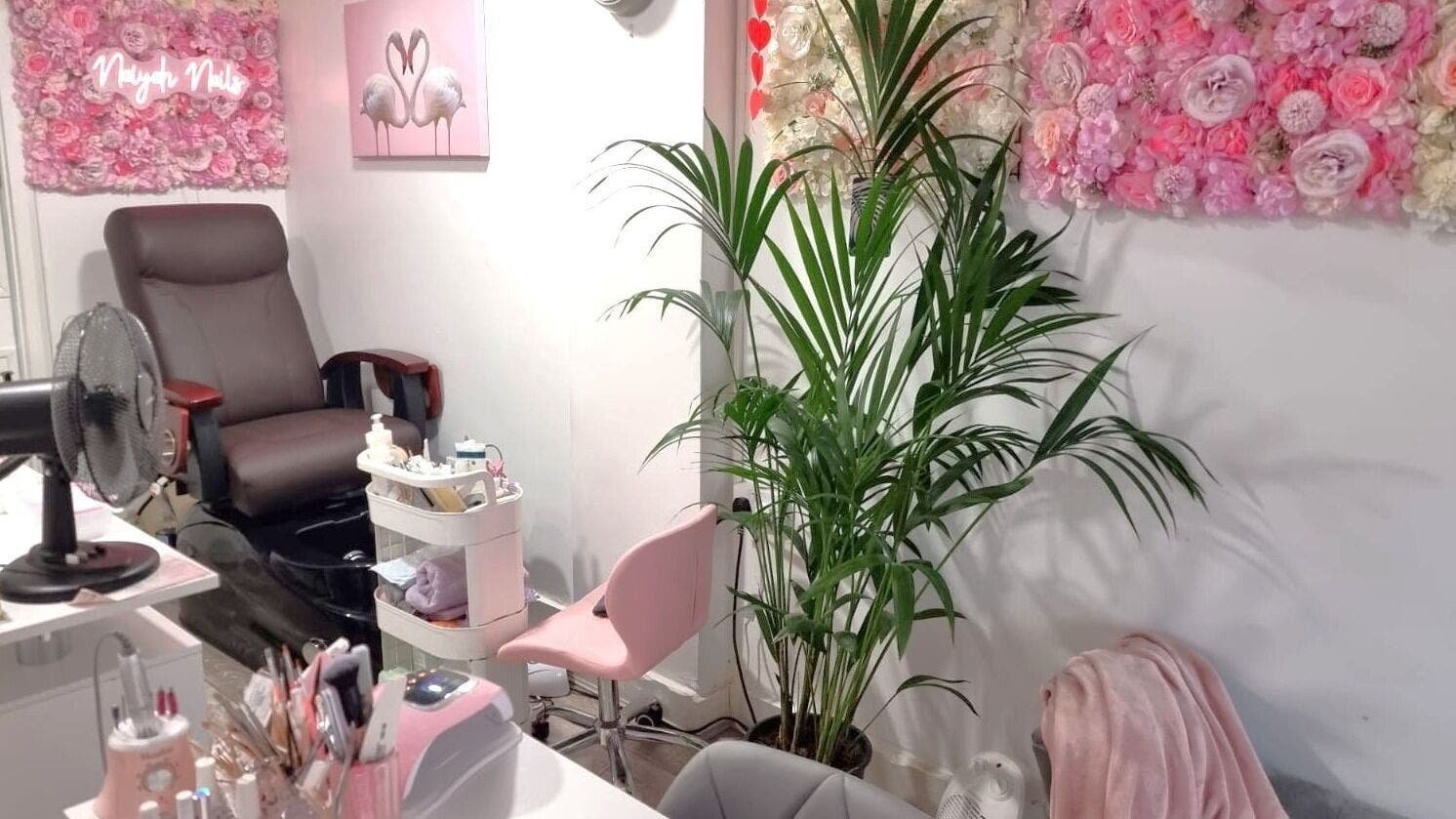 Chic Naiyah Nails salon in London, England, GB with floral decor and comfortable seating for a relaxing experience.