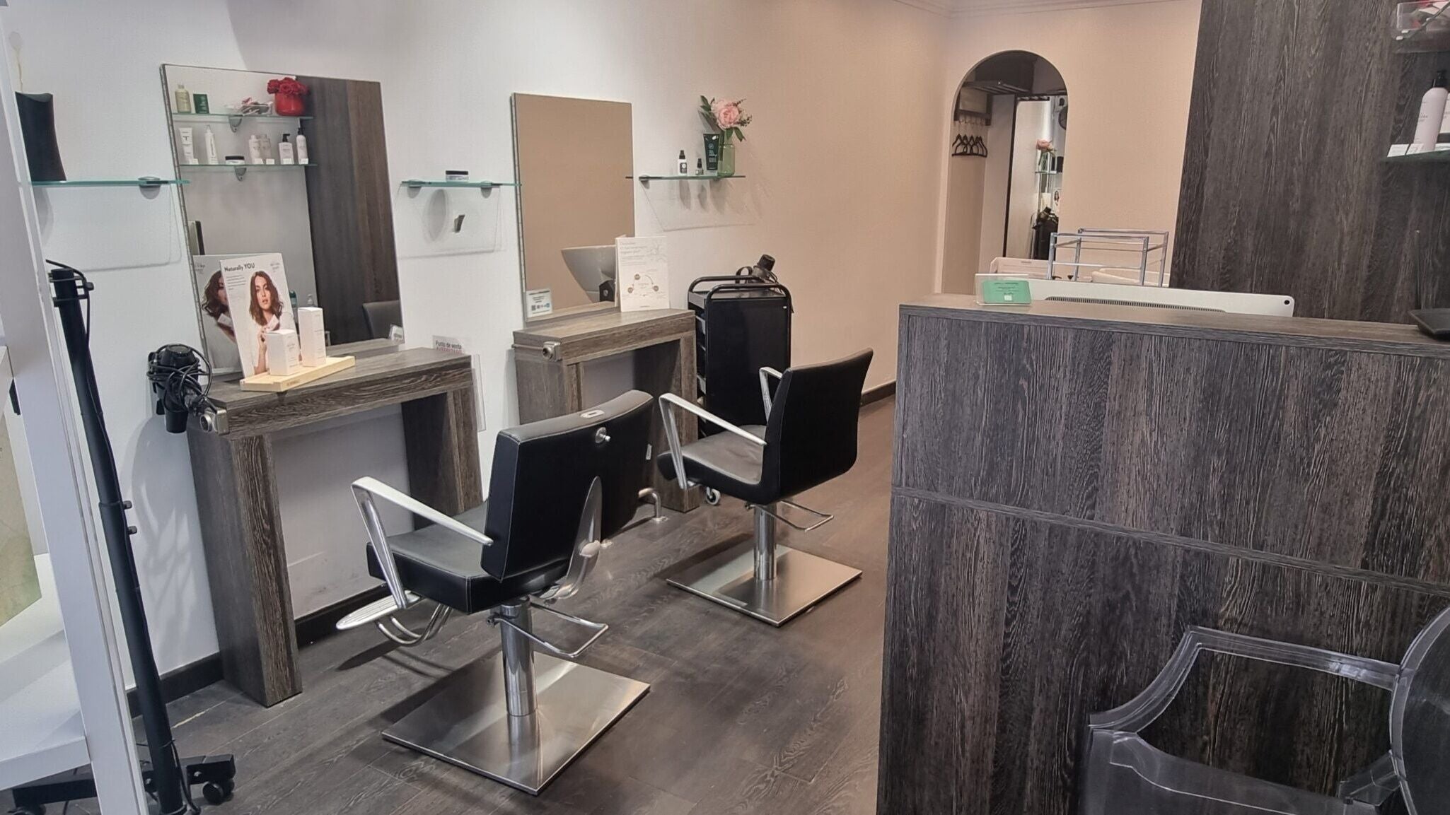 Interior moderno de AXICIAhair PERRUQUERIA en Barcelona, Catalunya, ES, con sillas y espejos elegantes.