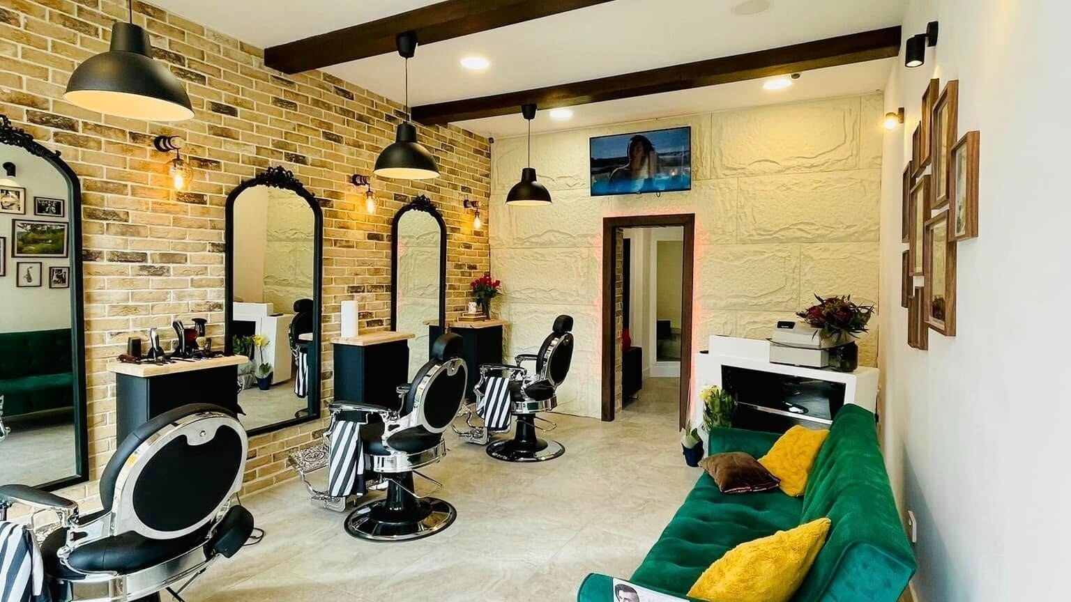 Modern interior of Mossimo Barbers, Glasgow, Scotland, GB showcasing stylish chairs and mirrors.