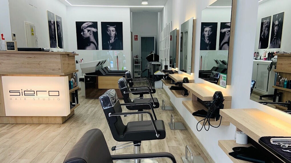 Interior de Siëro Hair en Madrid, Comunidad De Madrid, ES. Muestra sillones modernos y espejos iluminados.
