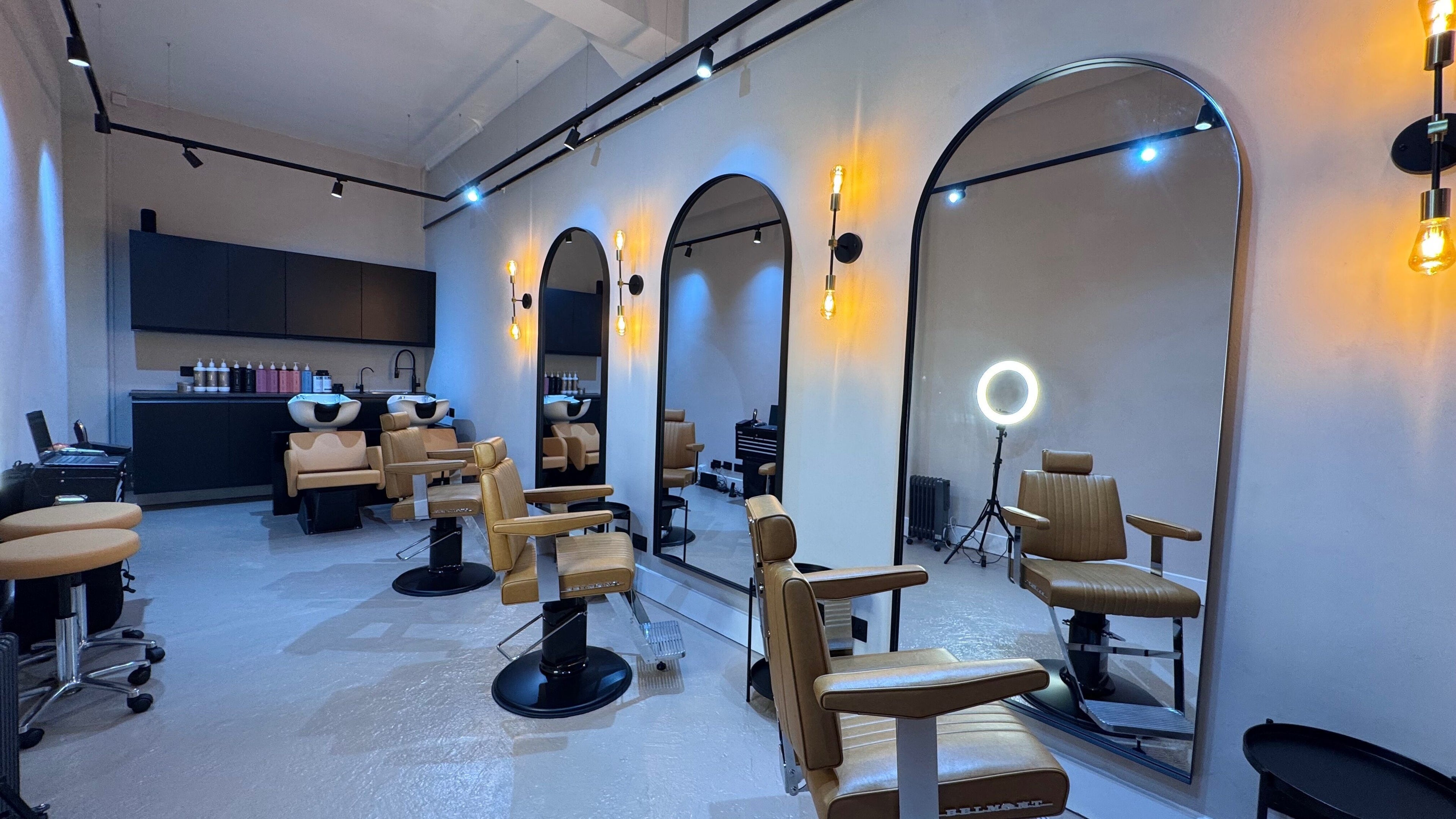 Modern salon at Yss Studio, London, England, GB featuring sleek mirrors and stylist chairs.