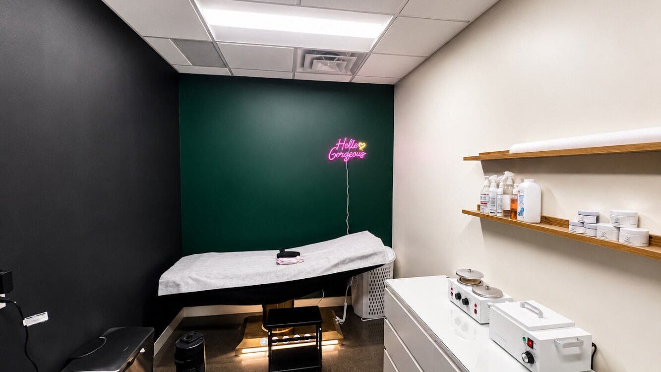 Modern treatment room at Comfort Wax Studio, Edmonton, Alberta, CA with cozy decor and neon sign.