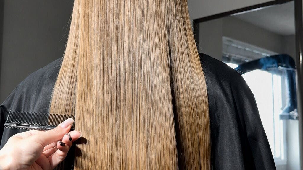 Smooth, straightened hair being combed at Perfect Hair in Calgary, Canada, CA.