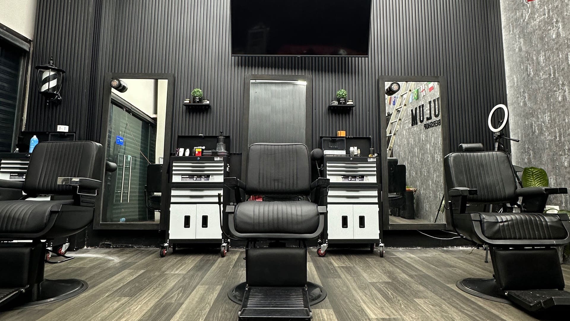 Interior elegante de Tulum Barbershop Barbería CDMX, con sillas de barbería negras en Ciudad De México, MX.