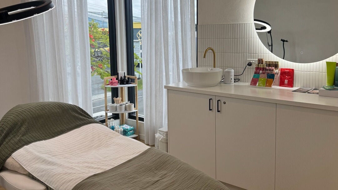 Elegant treatment room at Defined Cosmetics in Labrador, Queensland, AU, featuring a plush bed and serene decor.