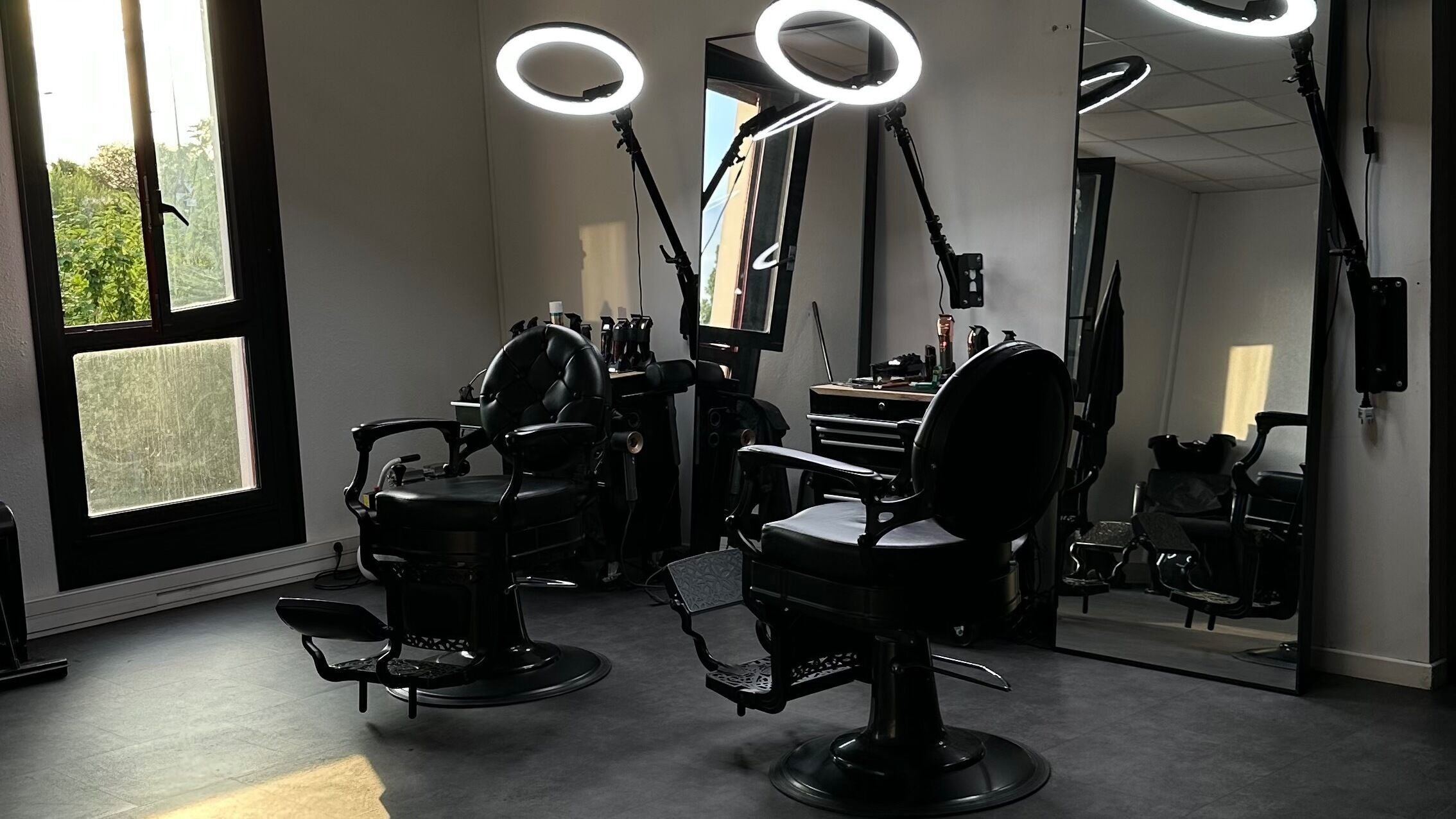 Intérieur du salon ART CUT à Éragny, Île-de-France, FR avec fauteuil de coiffeur élégant et éclairage moderne.