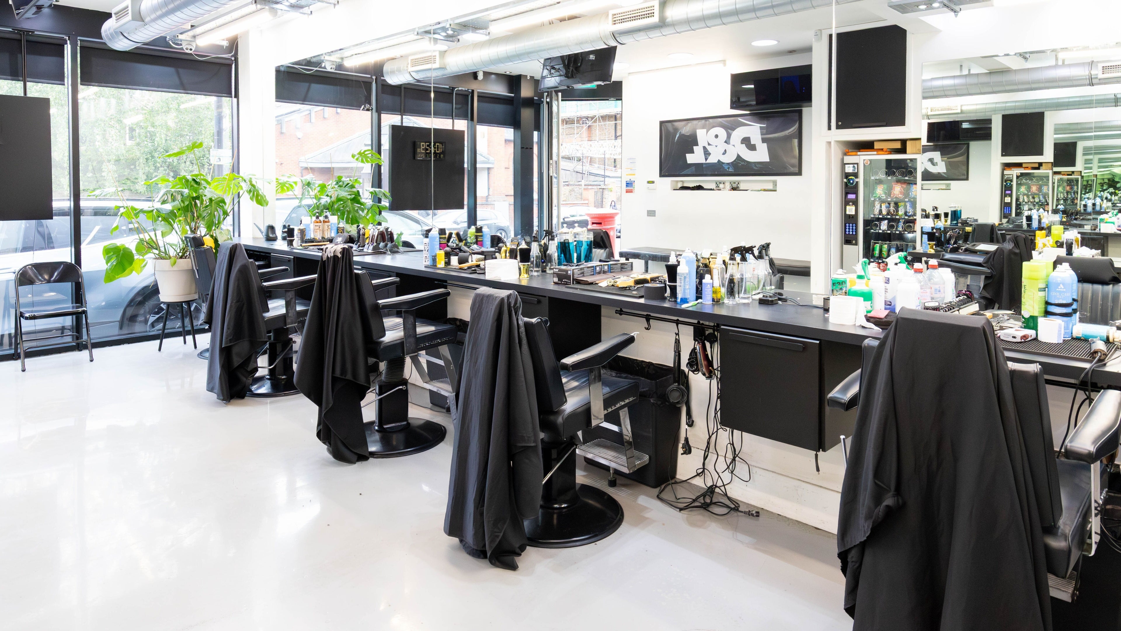 Spacious, modern interior of Damon The Barber in London, England, GB with sleek chairs and bright natural light.