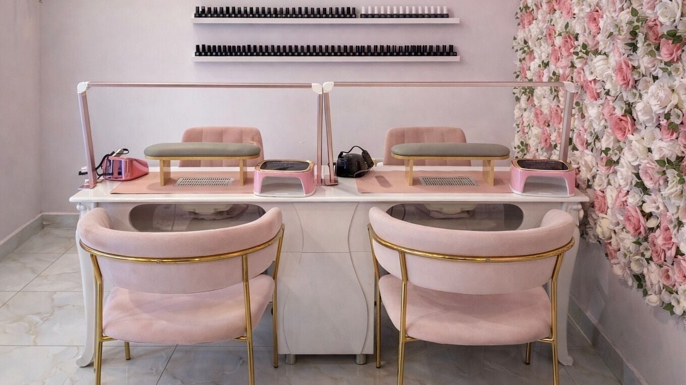 Chic nail station at Glow it - Luxe allround beauty salon, Limenas Chersonisou, GR with pink chairs and floral wall.