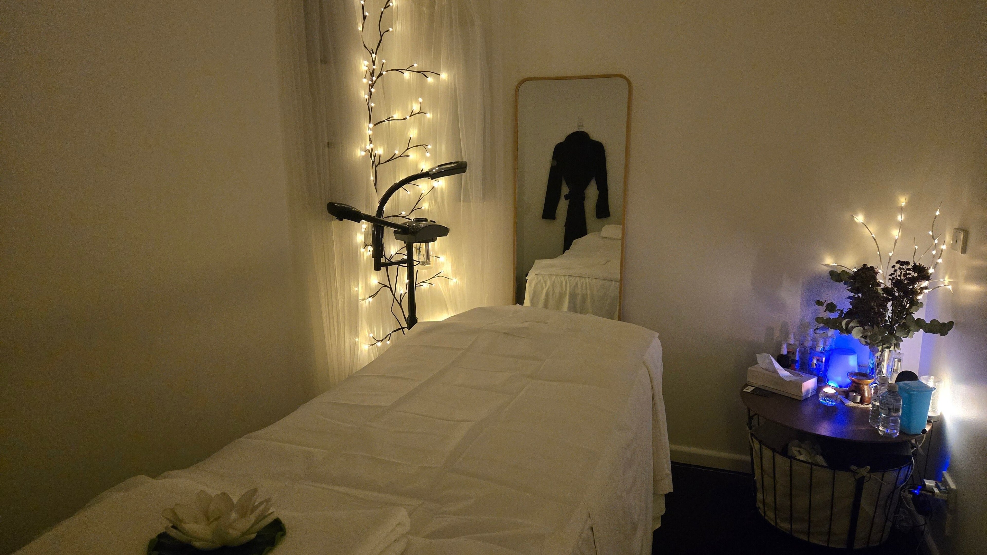 Relaxing massage room at V.A. Spa, Prahran, Victoria, AU with ambient lighting and floral decor.