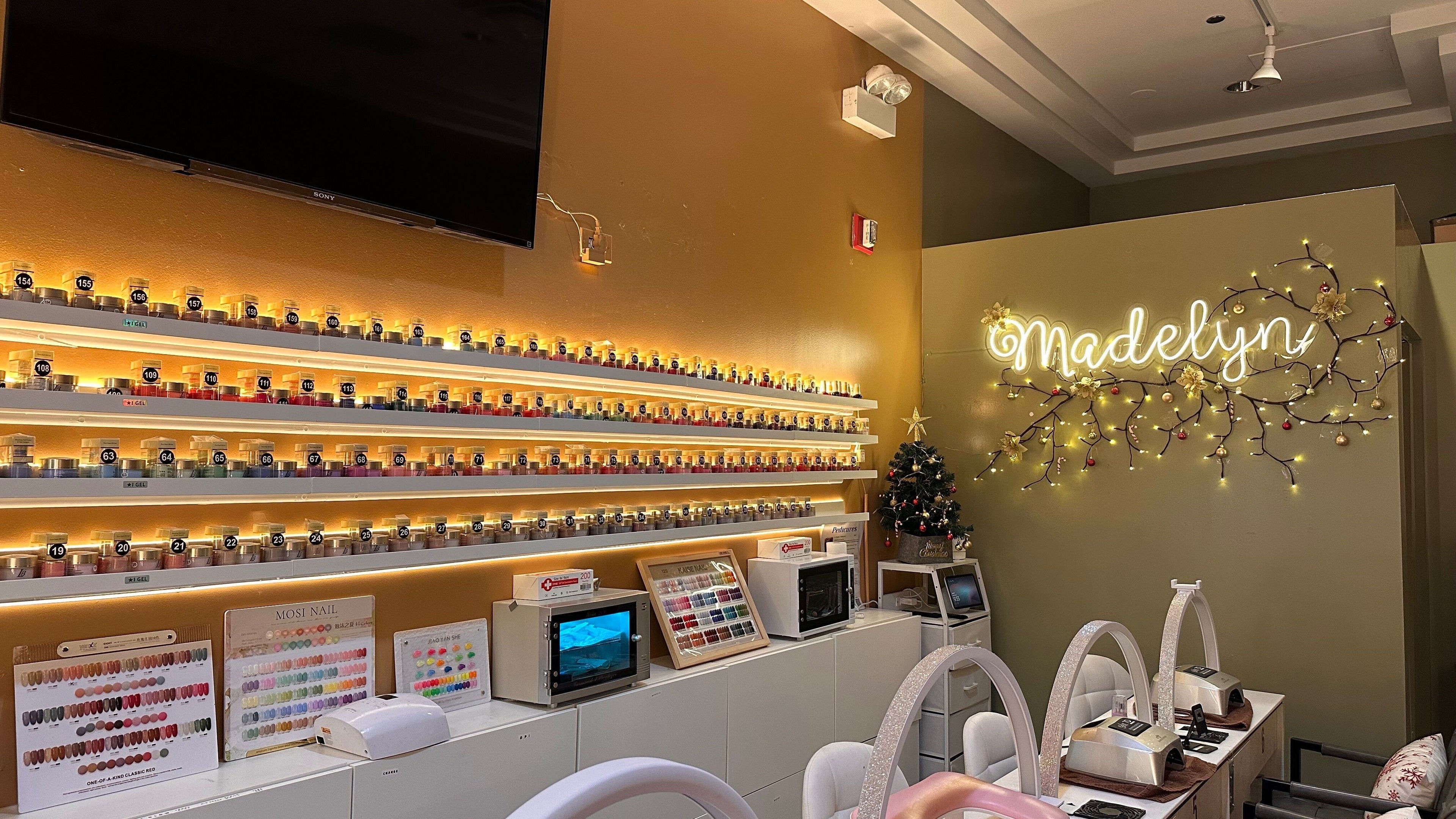 Vibrant nail polish display at Madelyn Chicago Nail Spa, Chicago, Illinois, US, with decorative lighting.