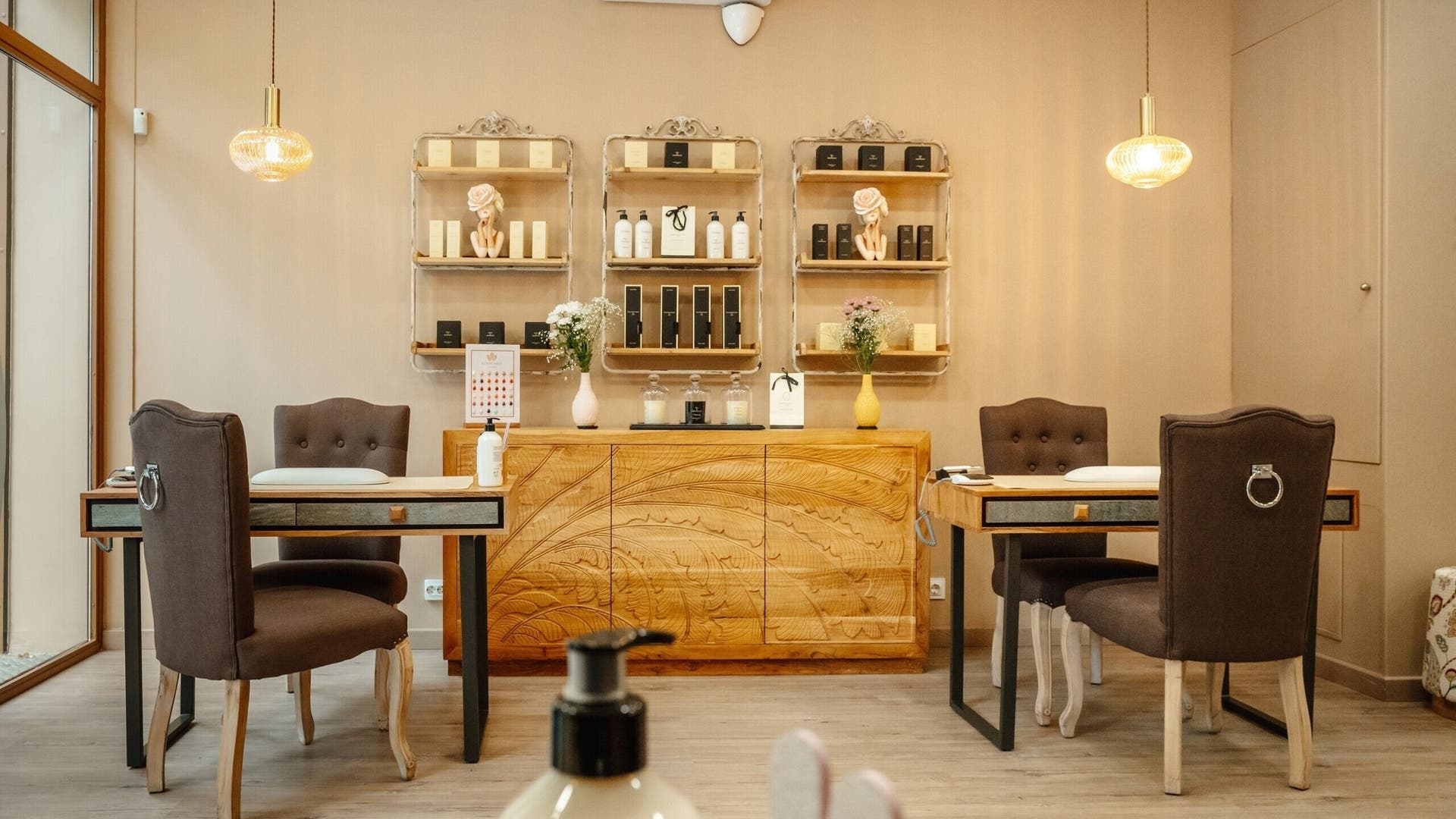 Interior elegante de Bloom Nails & Beauty Boutique en Barcelona, Catalunya, ES, con mesas y sillas modernas.