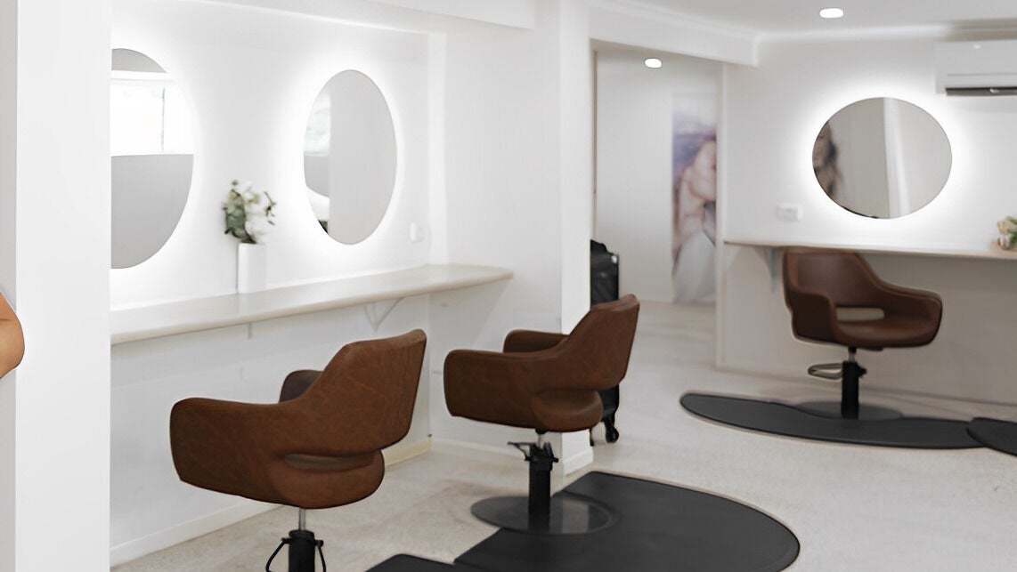 Stylish interior of Vanity Hair Lounge, Bundamba, Queensland, AU, featuring modern salon chairs and elegant mirrors.