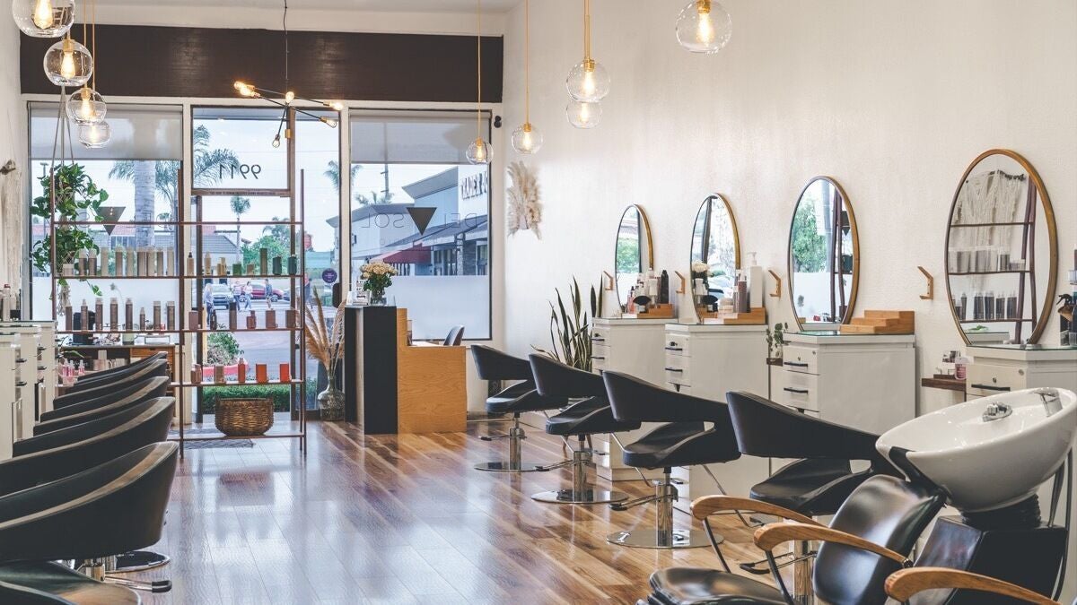 Interior of Del Sol Hair Studio in Huntington Beach, California, US, featuring stylish chairs and mirrors.