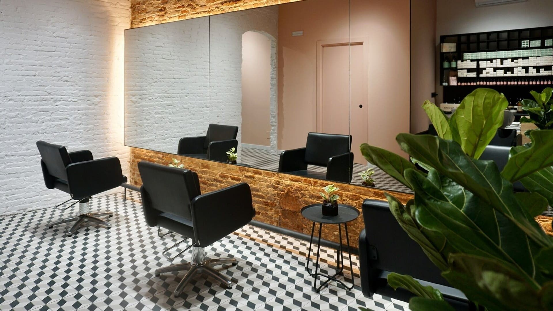Interior elegante de Lab4Hair en Barcelona, Catalunya, ES, con sillones de diseño frente a grandes espejos.